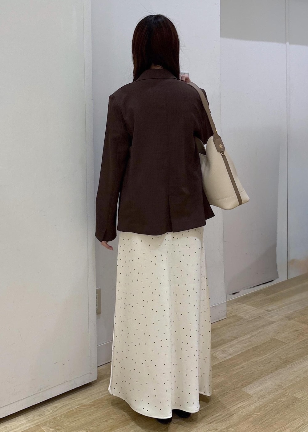 ホワイト系のショルダーバッグ、ベージュ系のTシャツ/カットソー、ブラウン系のテーラードジャケットを着用したレディースの春コーディネートの4枚目の写真