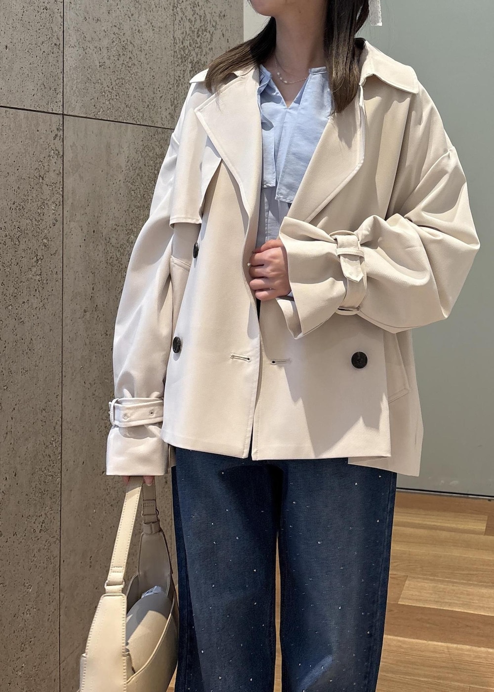 ベージュ系のハンドバッグ、ブルー系のデニムパンツ、ブルー系のシャツ/ブラウスを着用したレディースの春コーディネートの7枚目の写真