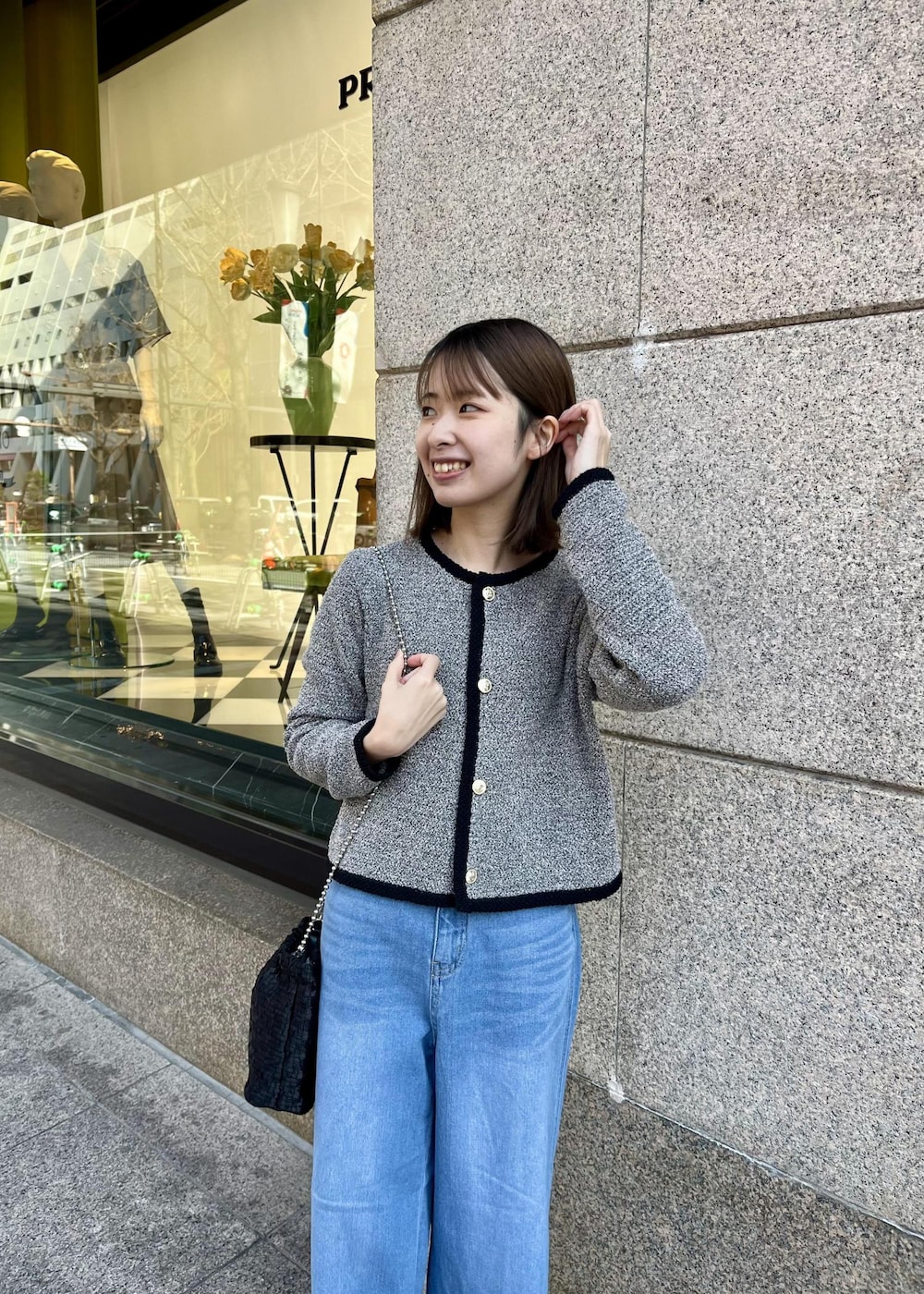 ブラック系のローファー、ブラック系のショルダーバッグ、ブルー系のデニムパンツを着用したレディースの春コーディネートの3枚目の写真