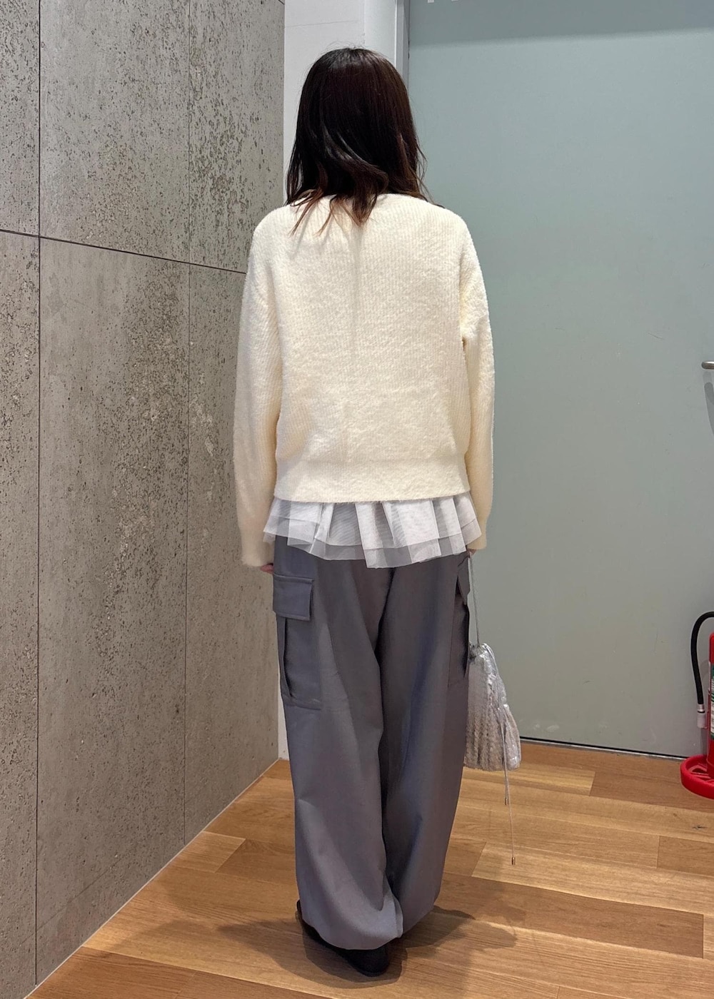 ホワイト系のベスト、シルバー系のショルダーバッグ、ホワイト系のニット/セーターを着用したレディースの春コーディネートの3枚目の写真