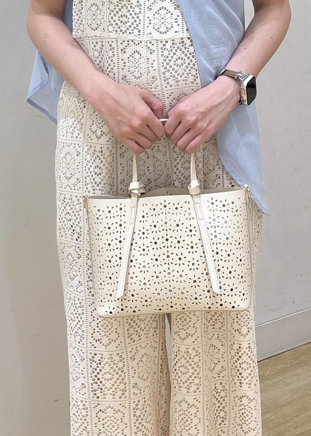 ホワイト系のショルダーバッグ、ブルー系のシャツ/ブラウス、ブラウン系のニット/セーターを着用したレディースの春コーディネートの8枚目の写真