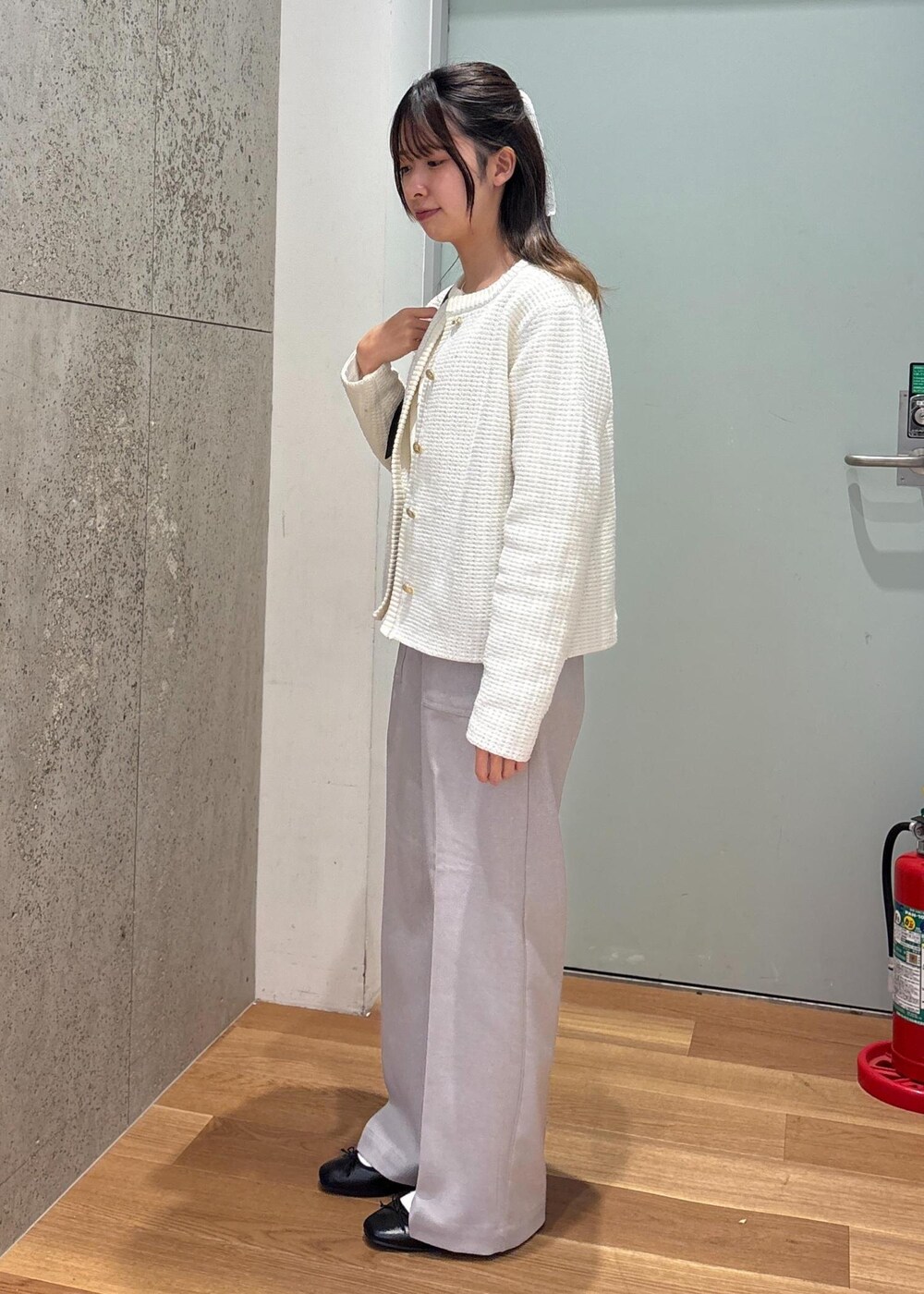 ブラック系のハンドバッグ、グレー系のその他パンツ、ホワイト系のカーディガン/ボレロを着用したレディースの春コーディネートの5枚目の写真