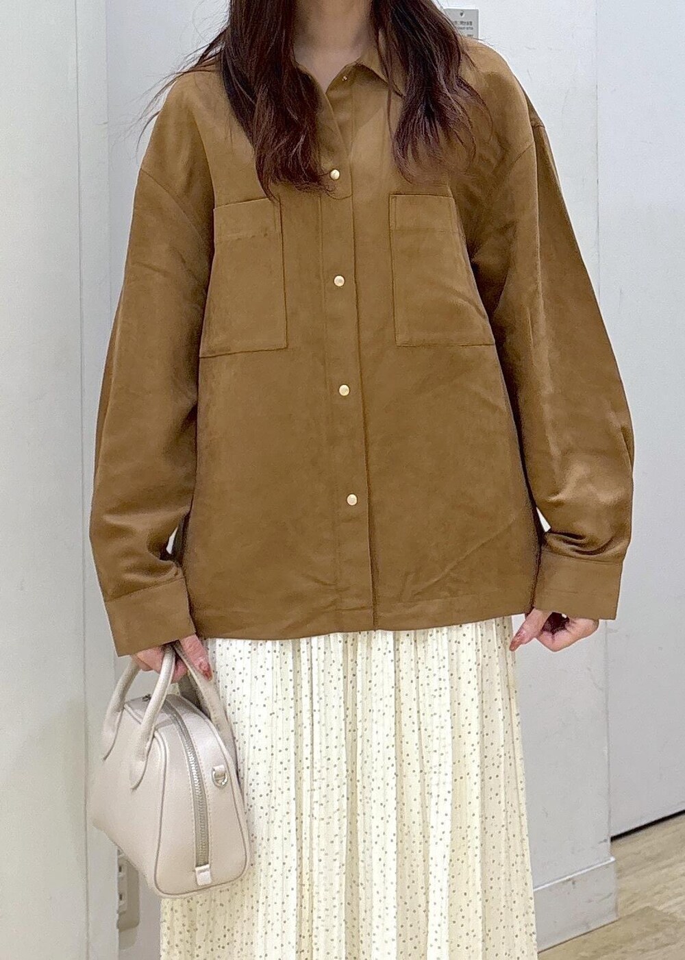 ホワイト系のスカート、ブラウン系のシャツ/ブラウス、ブラウン系のブーツを着用したレディースの秋コーディネートの5枚目の写真