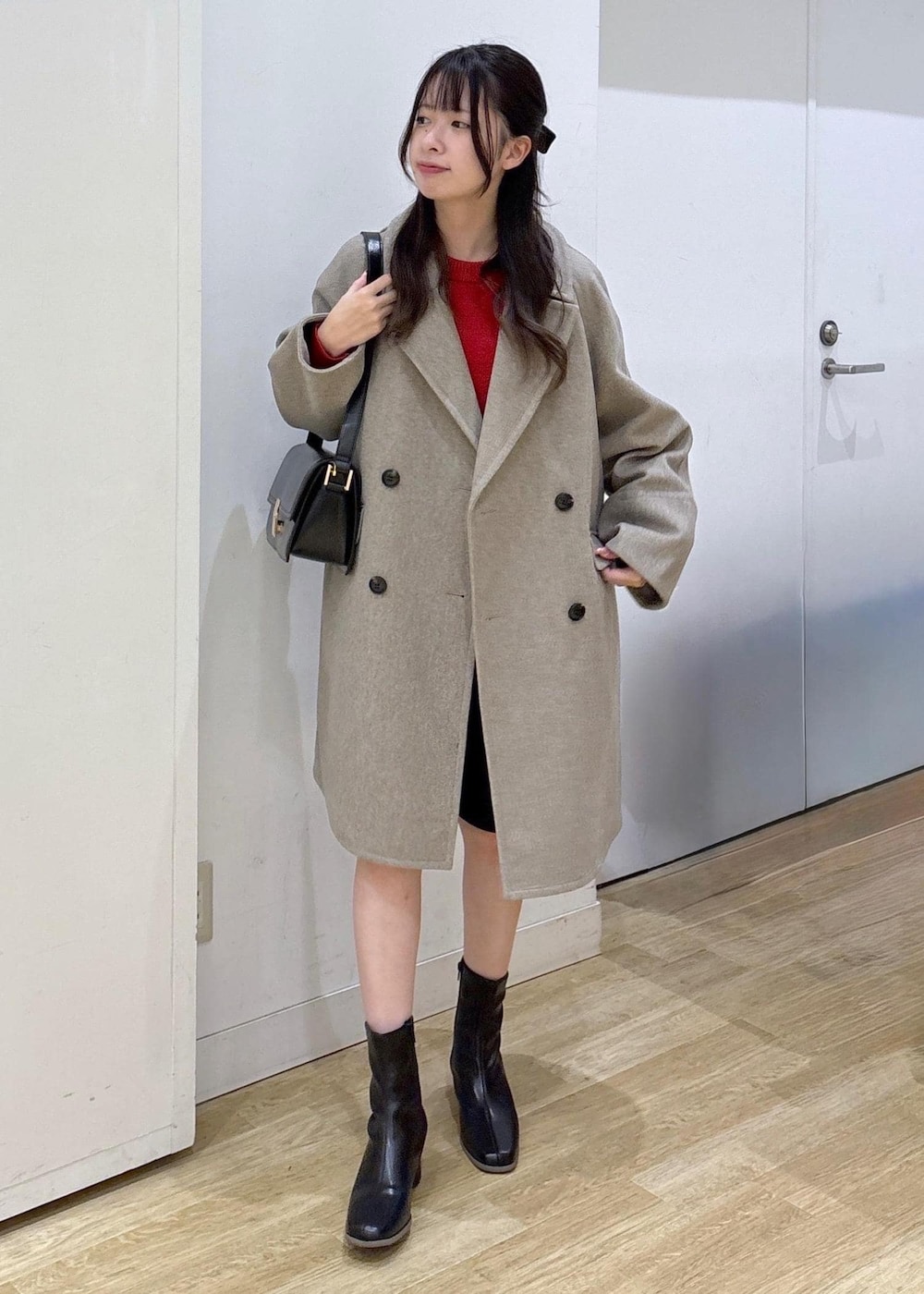 ブラック系のショルダーバッグ、レッド系のニット/セーター、ブラック系のブーツを着用したレディースの秋コーディネートの2枚目の写真