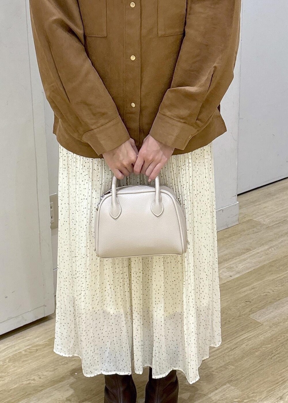 ホワイト系のスカート、ブラウン系のシャツ/ブラウス、ブラウン系のブーツを着用したレディースの秋コーディネートの6枚目の写真