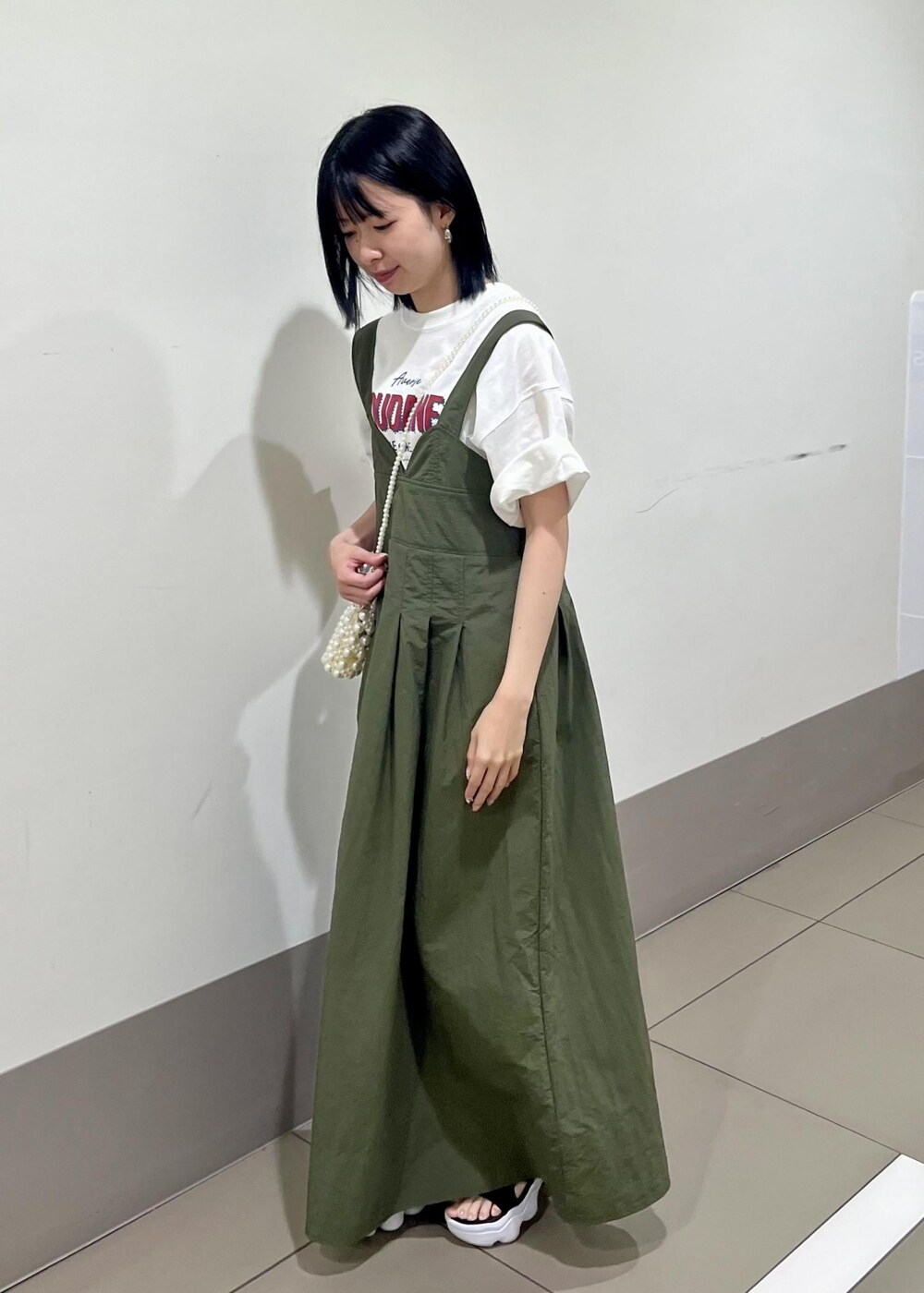 グリーン系のワンピース、ホワイト系のショルダーバッグ、ホワイト系のTシャツ/カットソーを着用したレディースの夏コーディネートの2枚目の写真