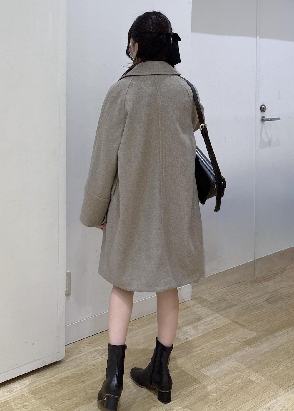 ブラック系のショルダーバッグ、レッド系のニット/セーター、ブラック系のブーツを着用したレディースの秋コーディネートの4枚目の写真