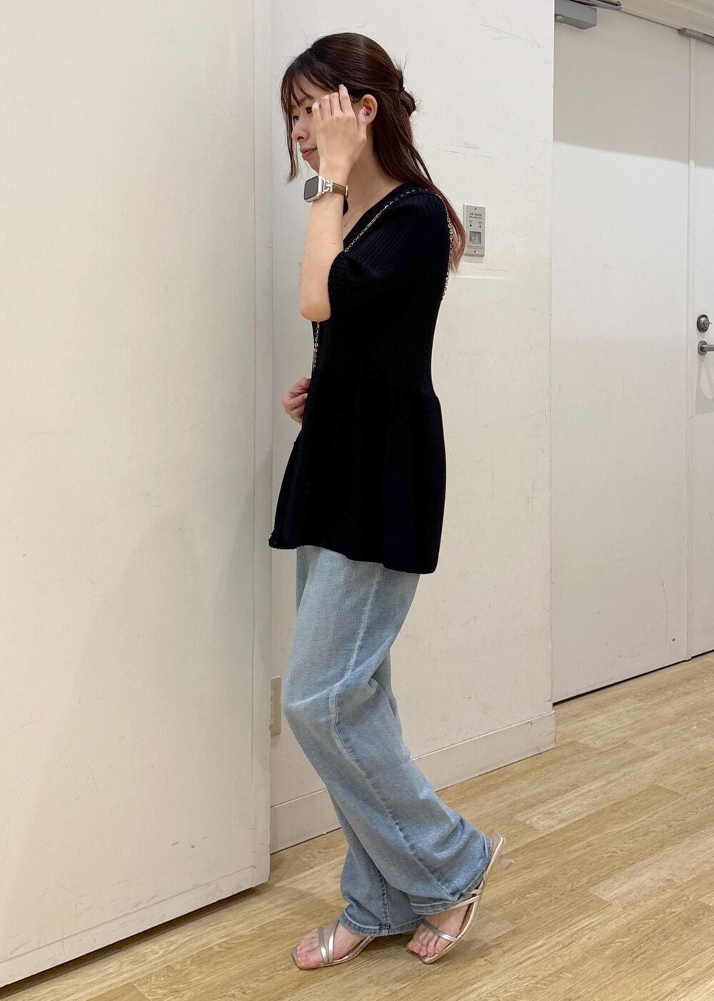 ブルー系のデニムパンツ、ブラック系のショルダーバッグ、シルバー系のサンダルを着用したレディースの夏コーディネートの2枚目の写真