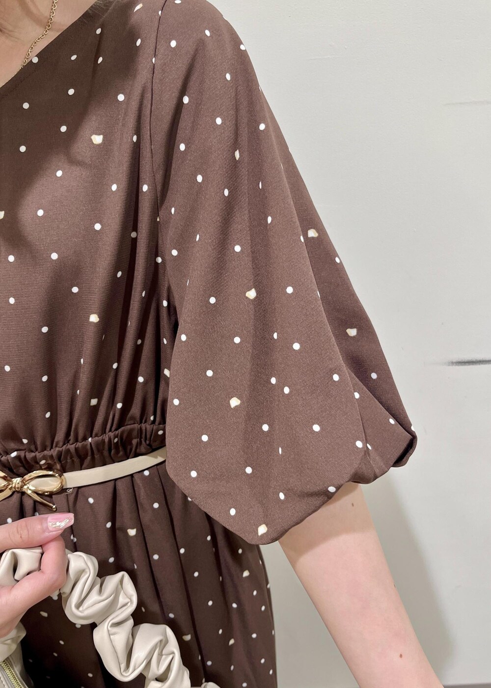 ホワイト系のハンドバッグ、ブラウン系のワンピース、ホワイト系のベルトを着用したレディースの春コーディネートの5枚目の写真