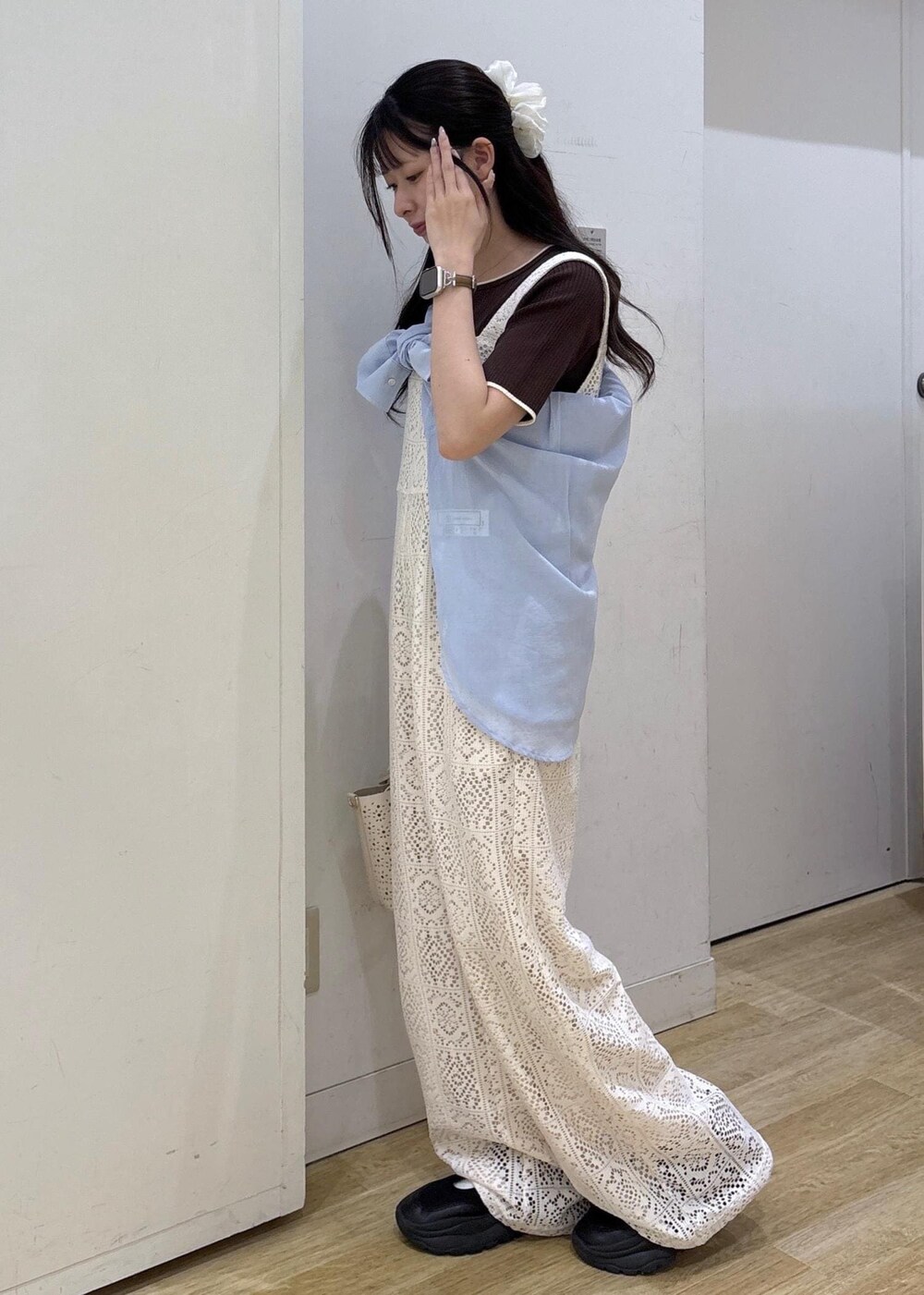 ホワイト系のショルダーバッグ、ブルー系のシャツ/ブラウス、ブラウン系のニット/セーターを着用したレディースの春コーディネートの5枚目の写真