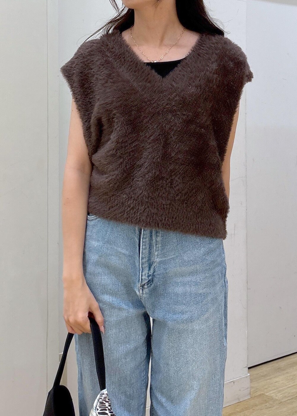 ブルー系のデニムパンツ、ブラック系のサンダル、ブラック系のショルダーバッグを着用したレディースの夏コーディネートの4枚目の写真