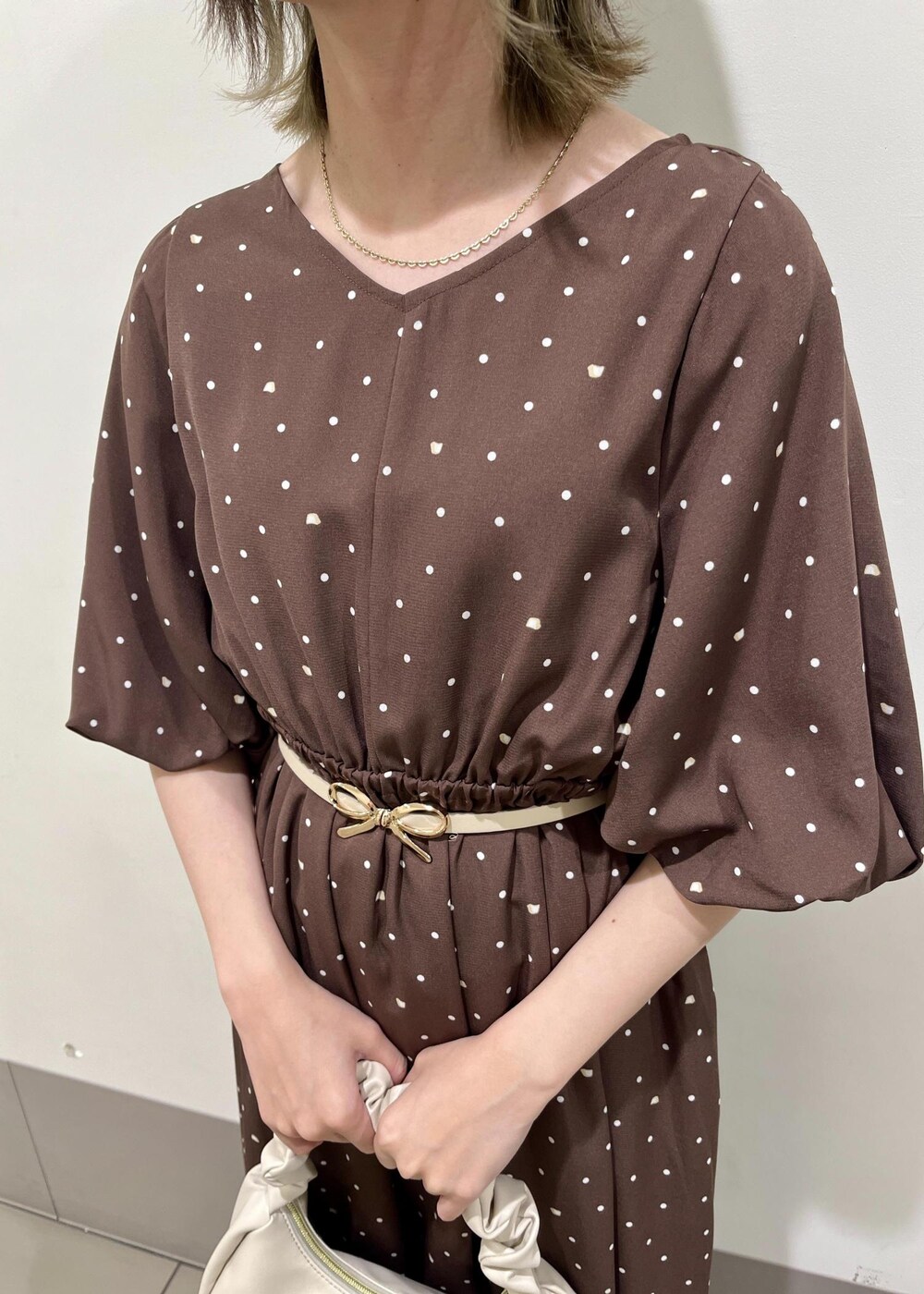 ホワイト系のハンドバッグ、ブラウン系のワンピース、ホワイト系のベルトを着用したレディースの春コーディネートの4枚目の写真