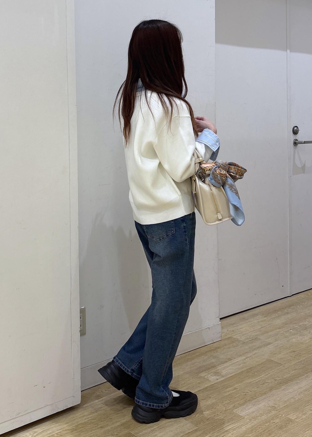 ホワイト系のボストンバッグ、ホワイト系のカーディガン/ボレロ、ブルー系のシャツ/ブラウスを着用したレディースの春コーディネートの3枚目の写真