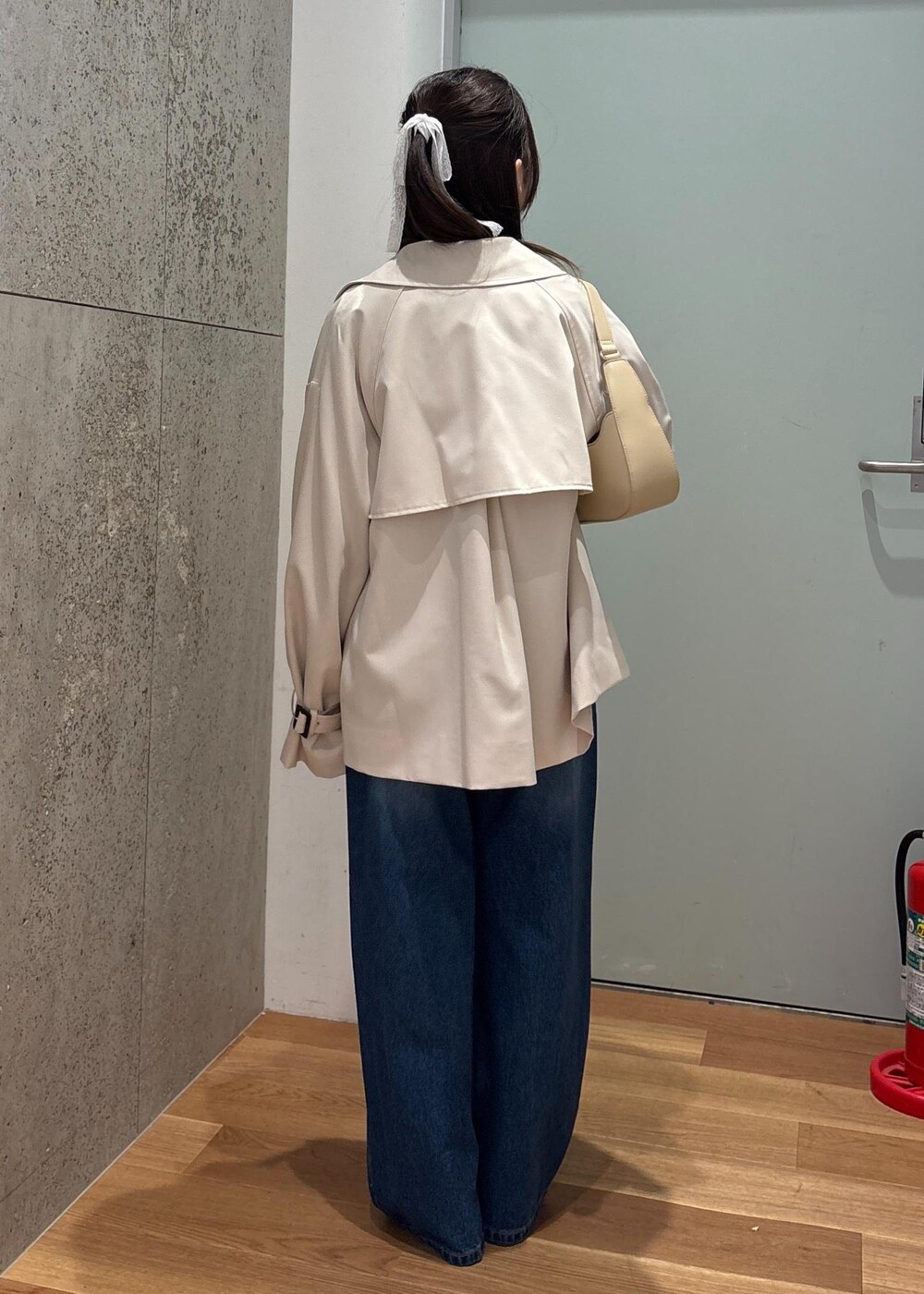 ベージュ系のハンドバッグ、ブルー系のデニムパンツ、ブルー系のシャツ/ブラウスを着用したレディースの春コーディネートの4枚目の写真