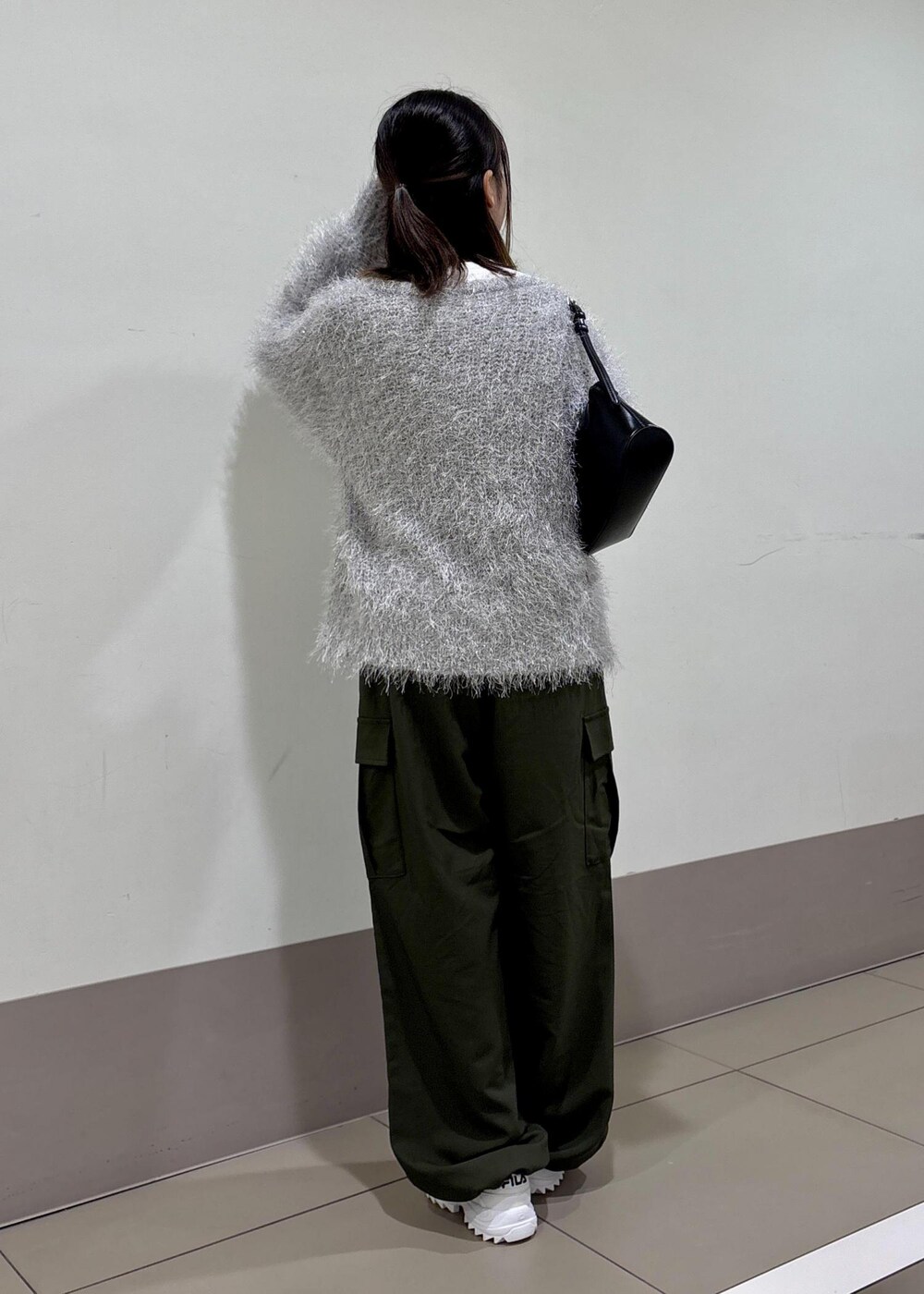 グレー系のカーディガン/ボレロ、ブラック系のショルダーバッグ、グリーン系のカーゴパンツを着用したレディースの秋コーディネートの3枚目の写真