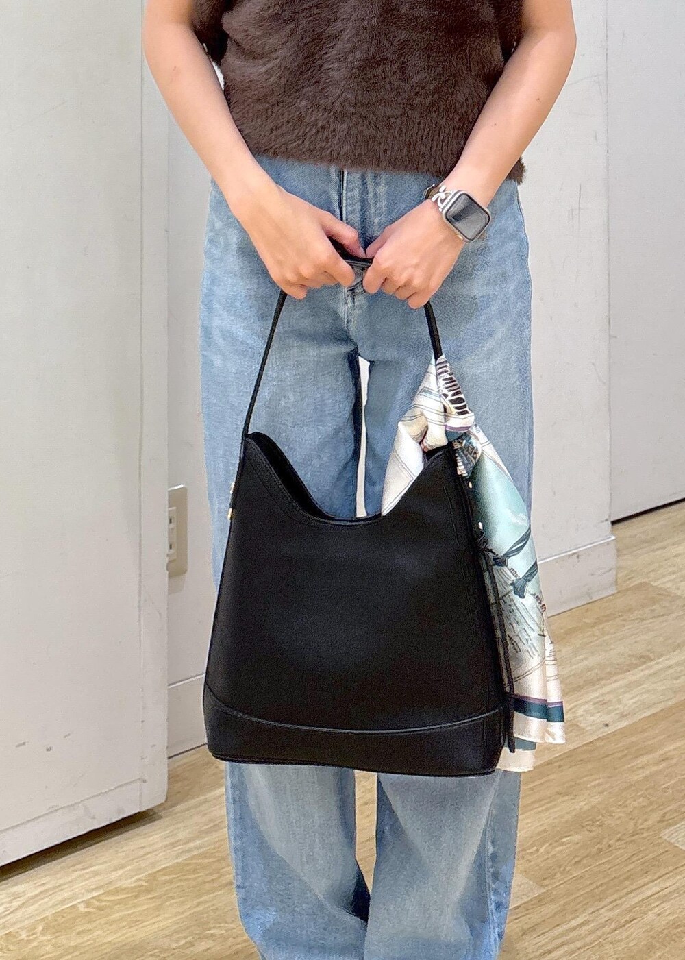 ブルー系のデニムパンツ、ブラック系のサンダル、ブラック系のショルダーバッグを着用したレディースの夏コーディネートの5枚目の写真