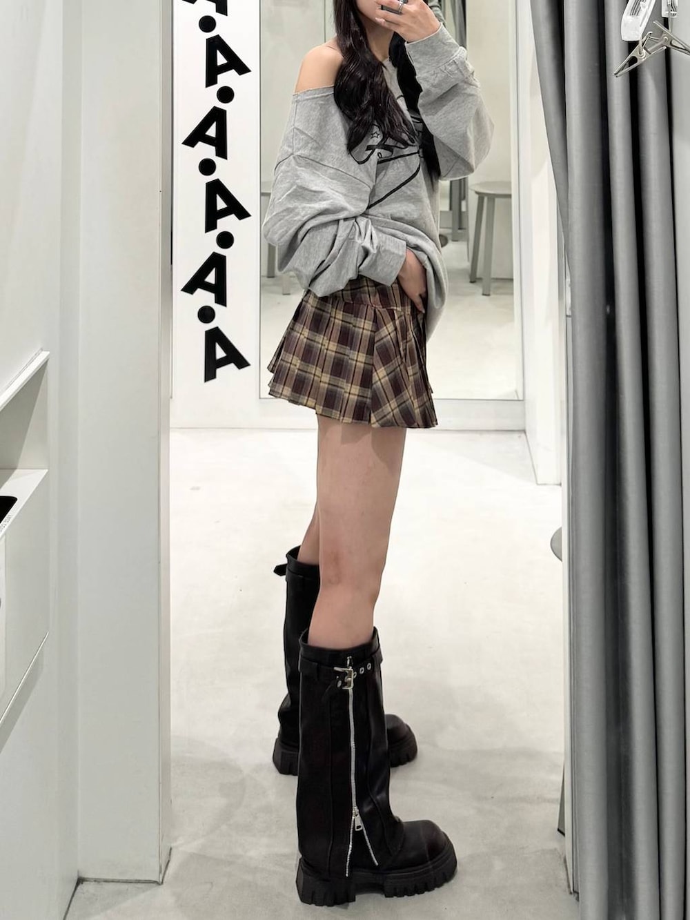 ベージュ系のスカート、ブラック系のブーツを着用したレディースの秋コーディネートの2枚目の写真