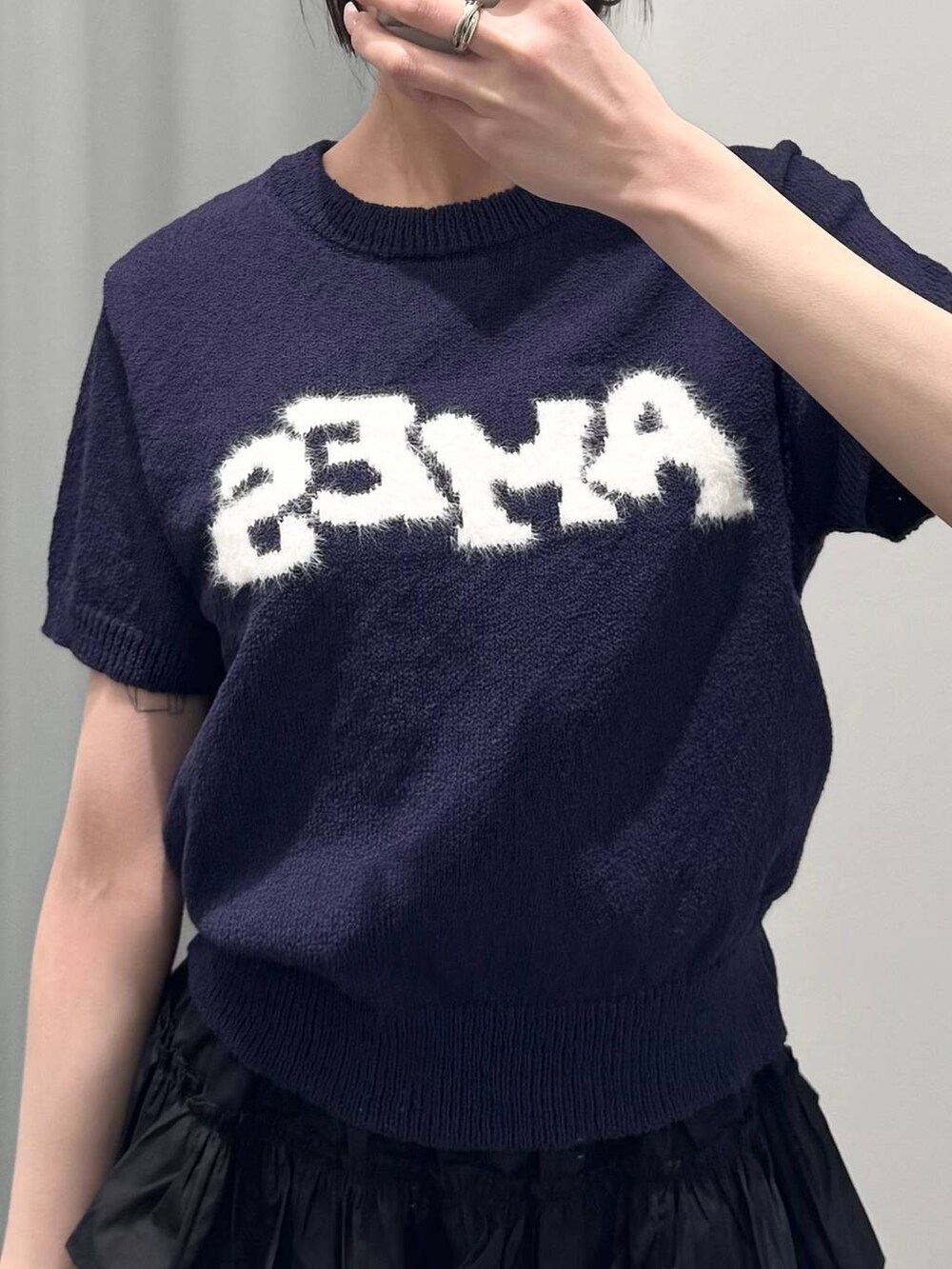 ブラック系のブーツ、シルバー系のショルダーバッグ、ブルー系のニット/セーターを着用したレディースの春コーディネートの3枚目の写真