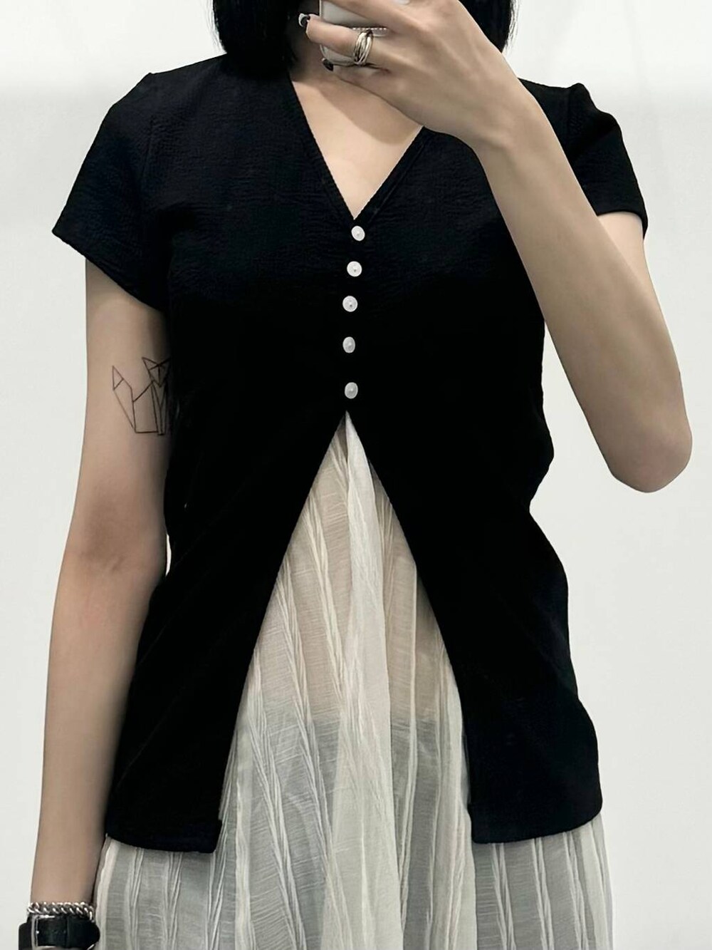 ブルー系のデニムパンツ、ホワイト系のワンピース、ブラック系のカーディガン/ボレロを着用したレディースの夏コーディネートの3枚目の写真