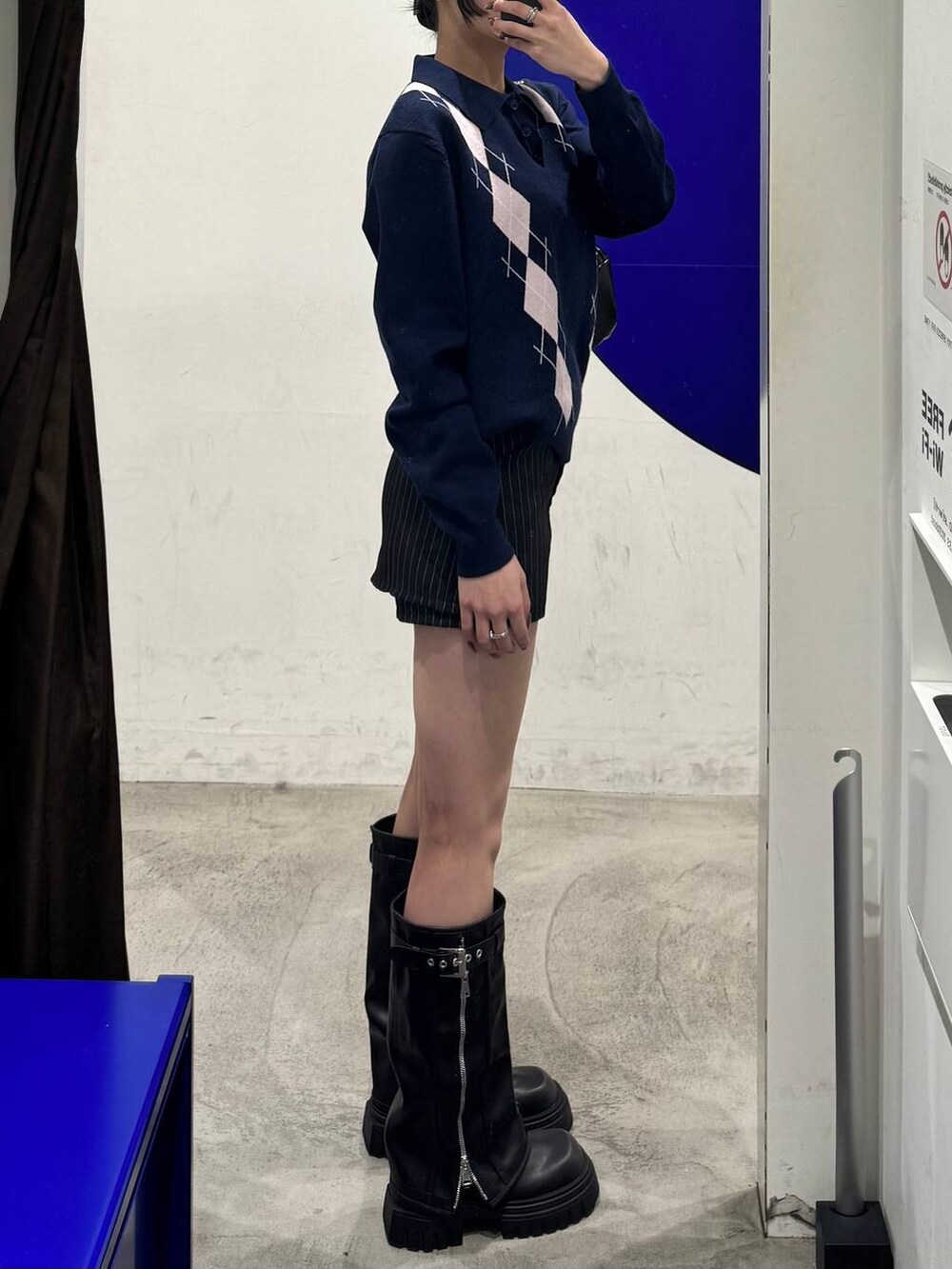 ブラック系のブーツ、ブルー系のニット/セーター、ブラック系のその他パンツを着用したレディースの冬コーディネートの2枚目の写真