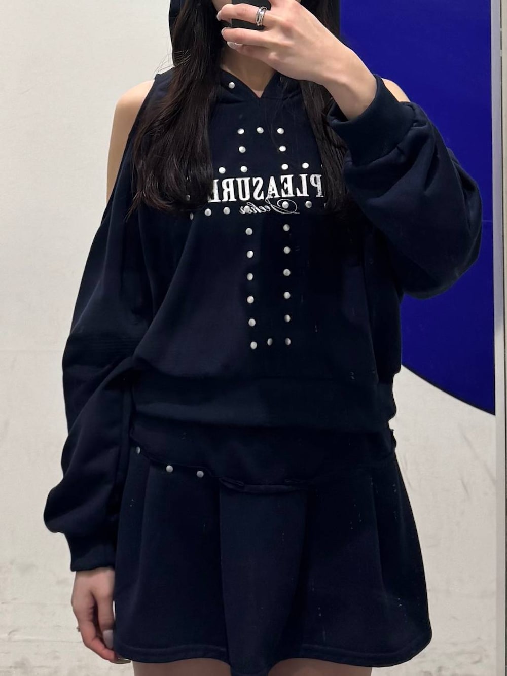 グレー系のハンドバッグ、ブルー系のスウェット、ブラック系のブーツを着用したレディースの春コーディネートの3枚目の写真