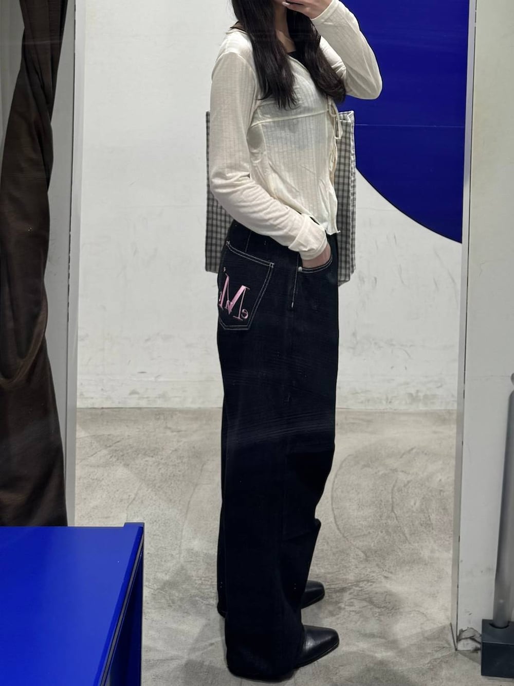 ホワイト系のトートバッグ、ホワイト系のカーディガン/ボレロ、ブラック系のデニムパンツを着用したレディースの春コーディネートの2枚目の写真