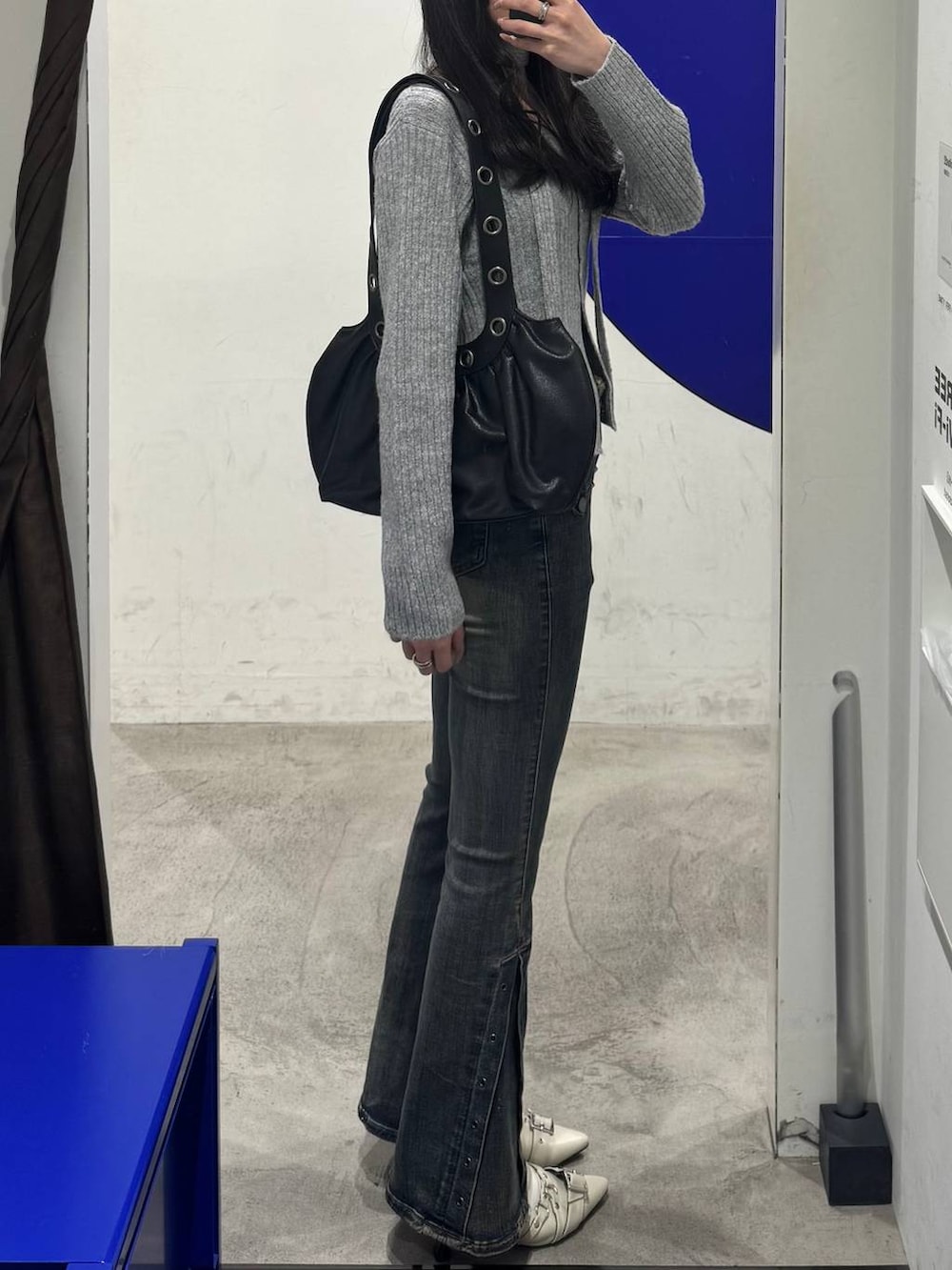 ホワイト系のパンプス、グレー系のカーディガン/ボレロ、ブルー系のデニムパンツを着用したレディースの冬コーディネートの2枚目の写真