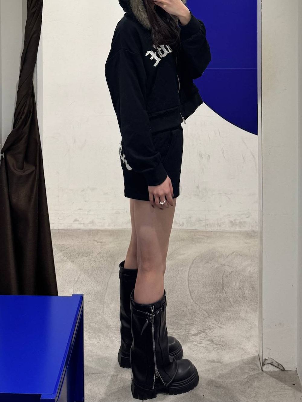 ブラック系のブーツ、ブラック系のパーカー、ブラック系のスウェットパンツを着用したレディースの冬コーディネートの2枚目の写真