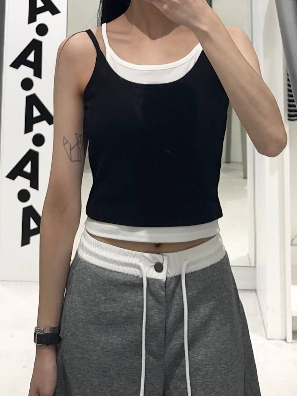 グレー系のその他パンツ、ブラック系のキャミソール、グリーン系のキャップを着用したレディースの夏コーディネートの3枚目の写真