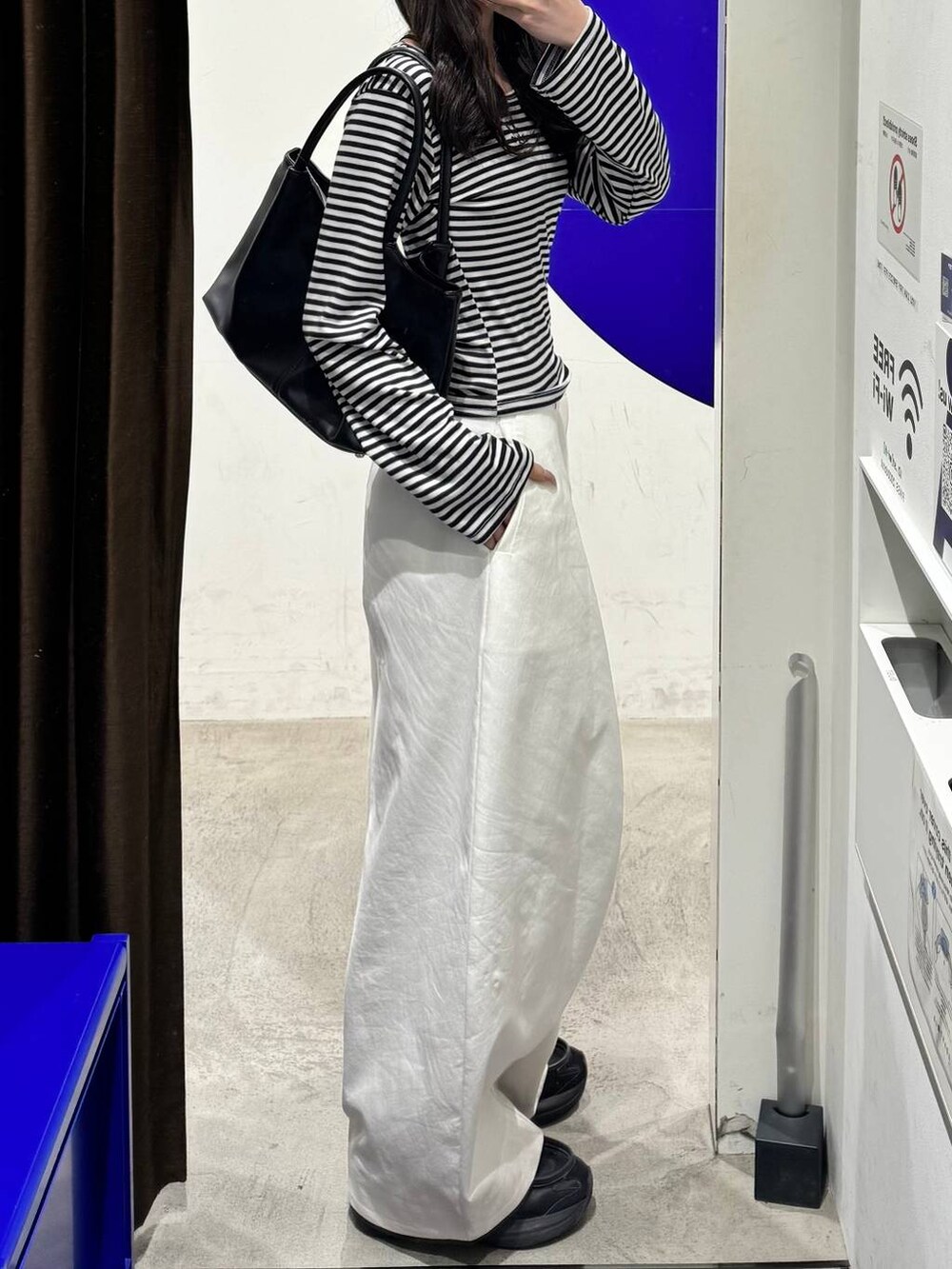 ホワイト系のその他パンツ、ブラック系のトートバッグ、ホワイト系のTシャツ/カットソーを着用したレディースの冬コーディネートの2枚目の写真