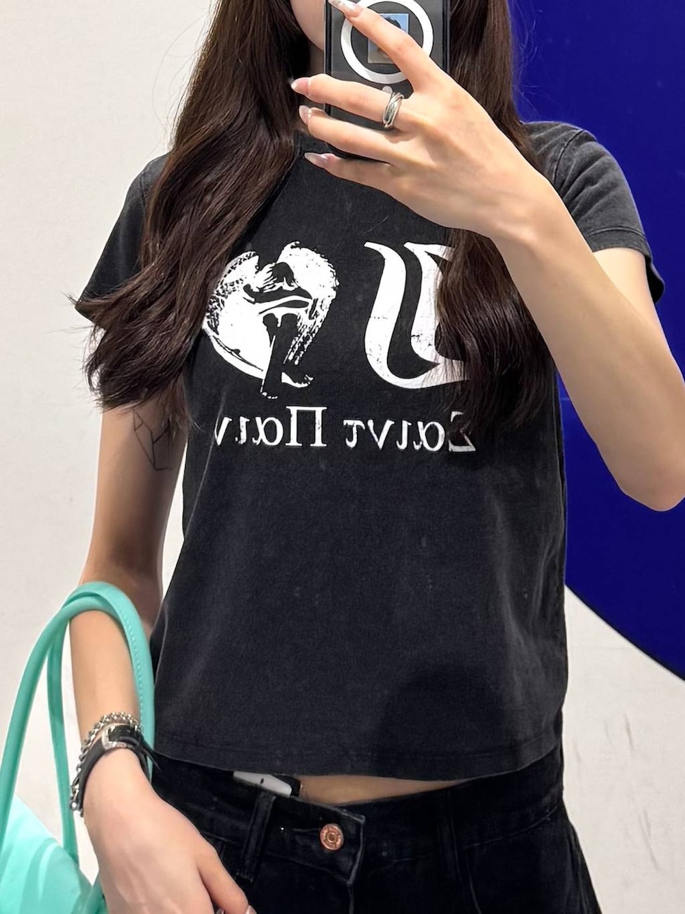 ブラック系のカーゴパンツ、ブラック系のTシャツ/カットソー、グリーン系のショルダーバッグを着用したレディースの夏コーディネートの3枚目の写真