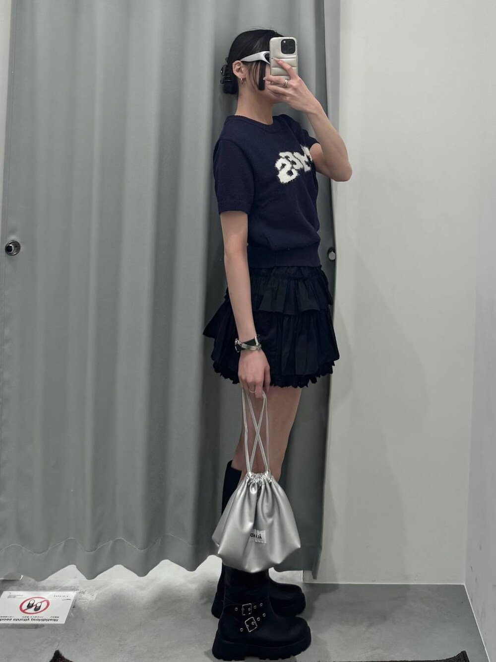 ブラック系のブーツ、シルバー系のショルダーバッグ、ブルー系のニット/セーターを着用したレディースの春コーディネートの2枚目の写真