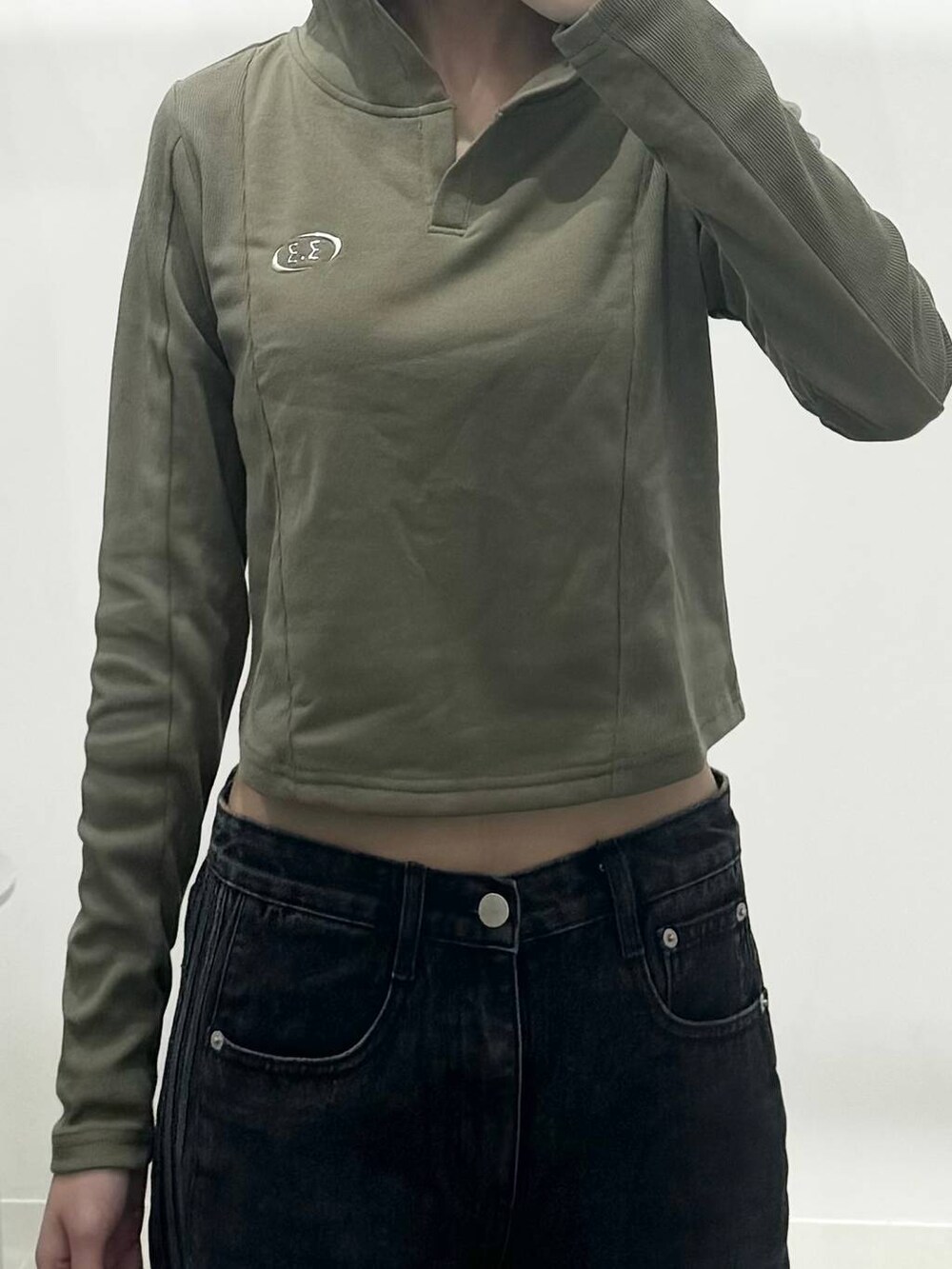 グリーン系のTシャツ/カットソー、ホワイト系のサンダル、ブラック系のデニムパンツを着用したレディースの秋コーディネートの3枚目の写真