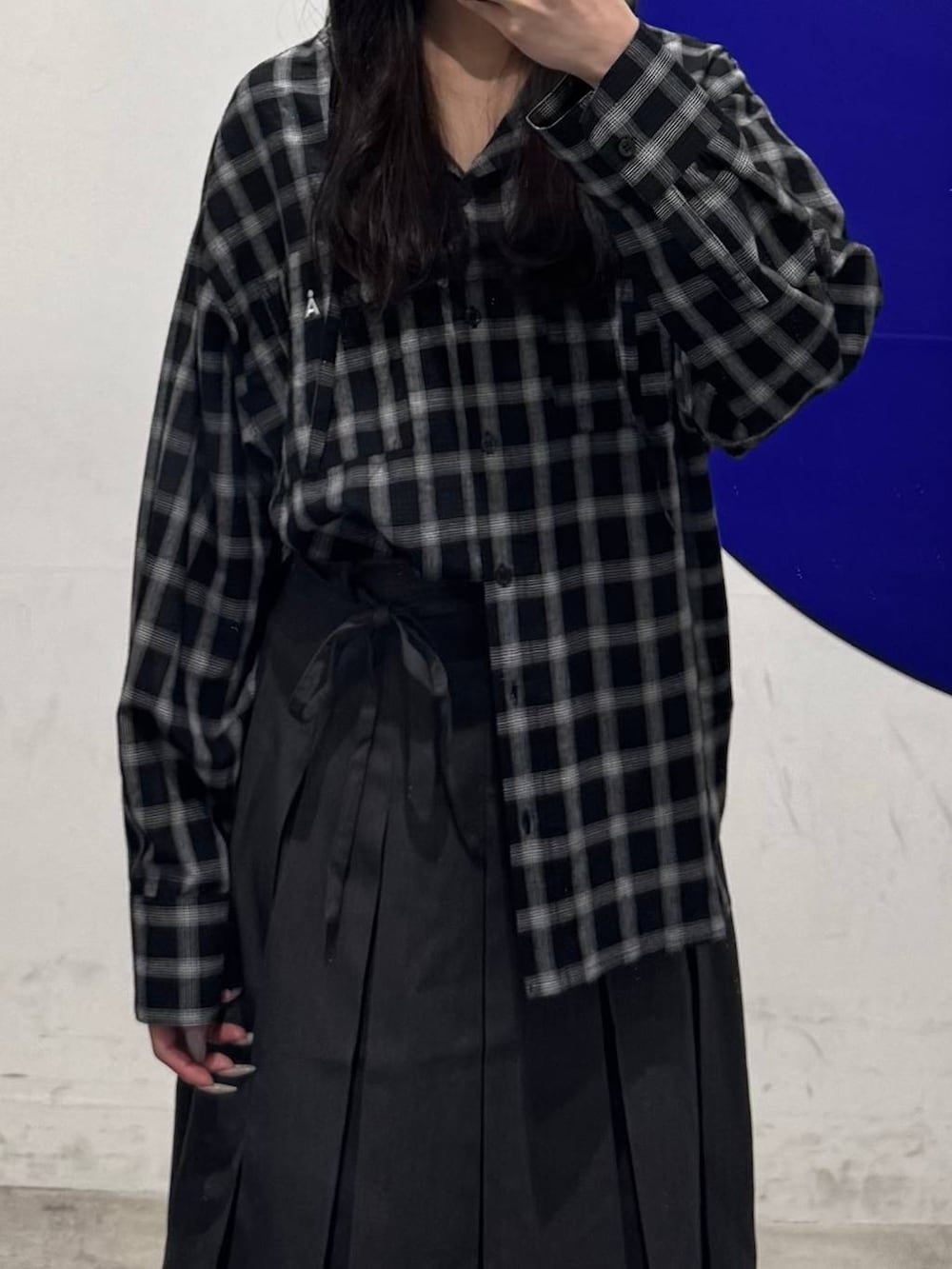 ブラック系のブーツ、グレー系のスカート、ブラック系のシャツ/ブラウスを着用したレディースの春コーディネートの3枚目の写真