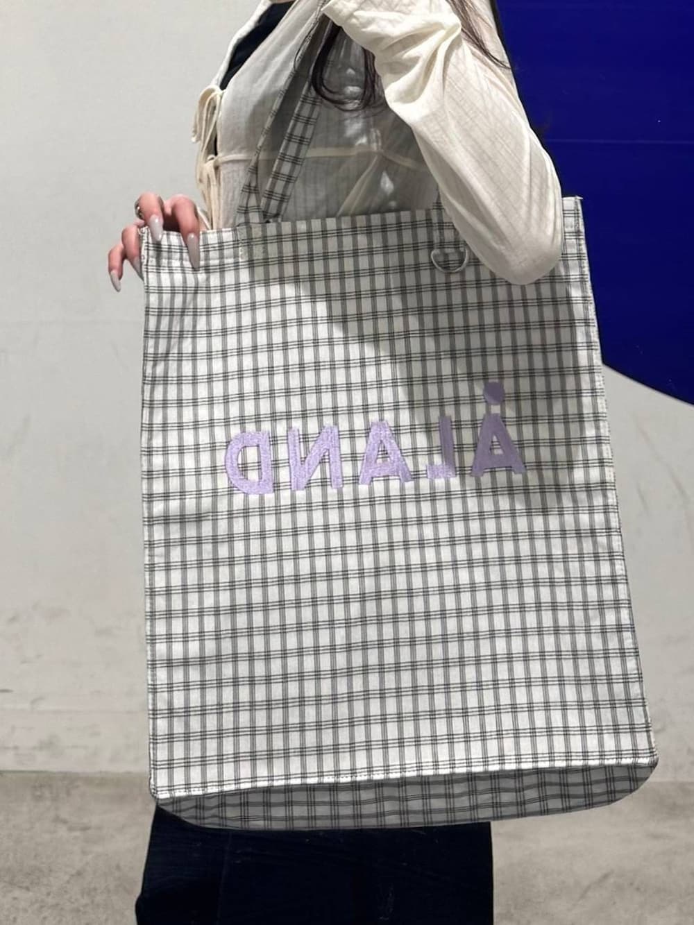 ホワイト系のトートバッグ、ホワイト系のカーディガン/ボレロ、ブラック系のデニムパンツを着用したレディースの春コーディネートの3枚目の写真