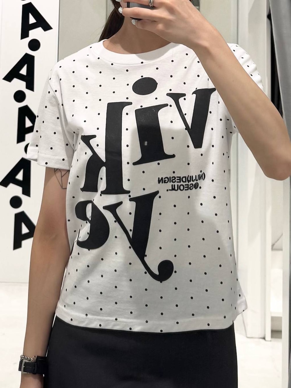 グレー系のスカート、ブラック系のブーツ、ホワイト系のTシャツ/カットソーを着用したレディースの夏コーディネートの3枚目の写真
