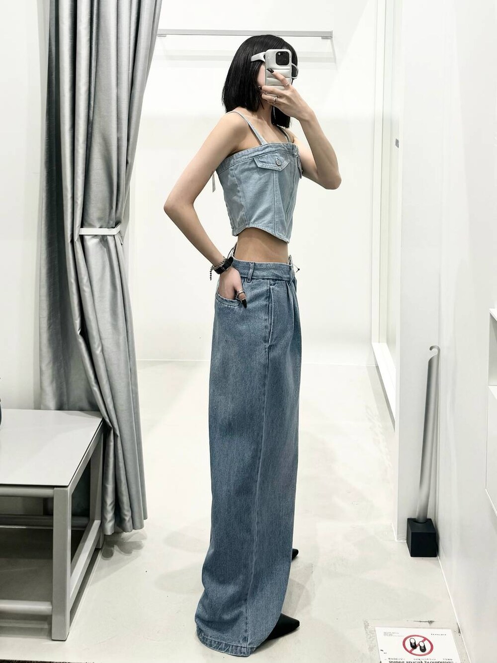 ブルー系のチューブトップ、ブルー系のデニムパンツ、ブルー系のトートバッグを着用したレディースの夏コーディネートの2枚目の写真