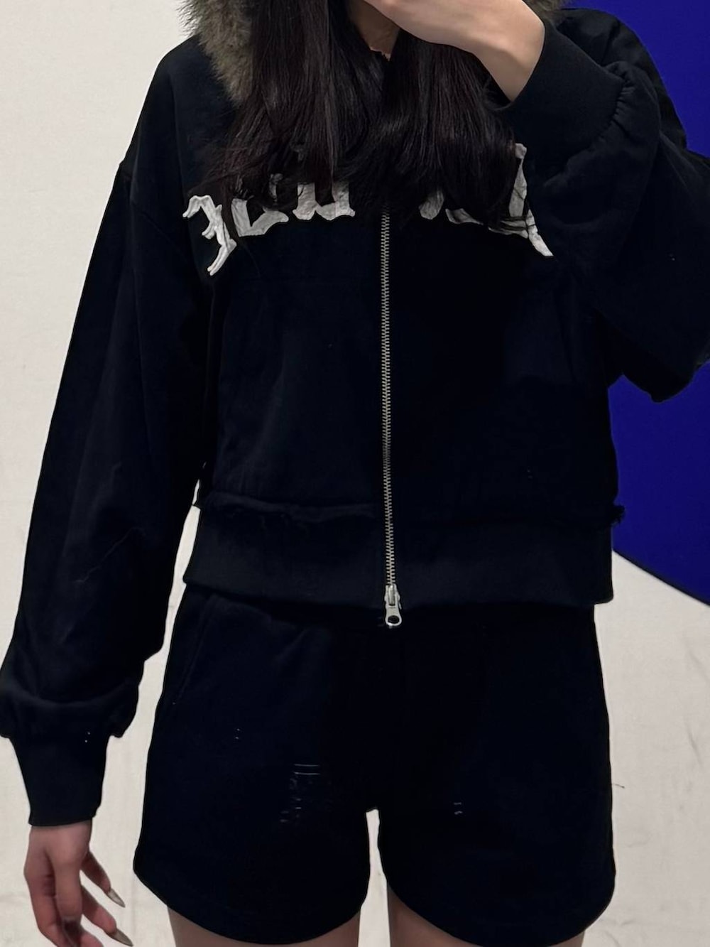 ブラック系のブーツ、ブラック系のパーカー、ブラック系のスウェットパンツを着用したレディースの冬コーディネートの3枚目の写真