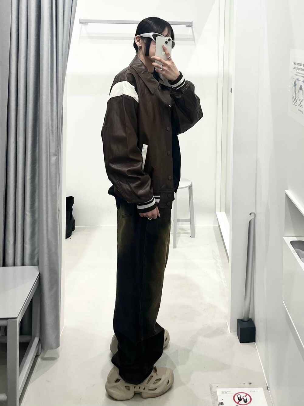 ブラウン系のライダースジャケット、ブラウン系のデニムパンツを着用したレディースの春コーディネートの2枚目の写真