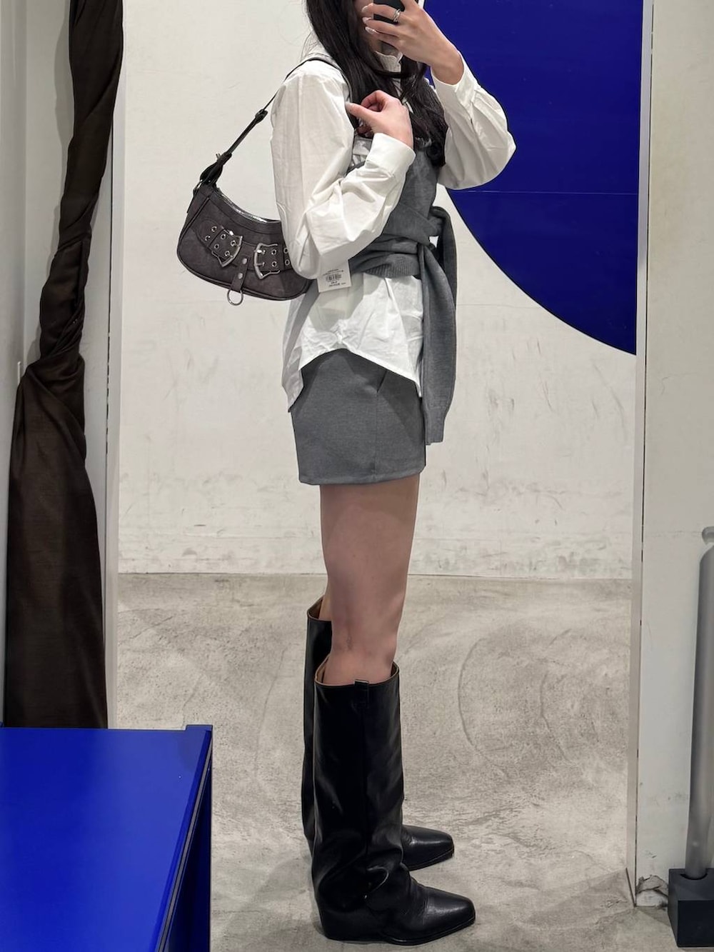 ホワイト系のシャツ/ブラウス、グレー系のその他パンツ、ブラック系のブーツを着用したレディースの春コーディネートの2枚目の写真