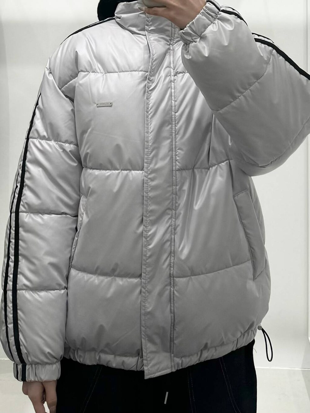 グレー系のダウンジャケット/コート、ブラック系のハンドバッグを着用したレディースの冬コーディネートの3枚目の写真