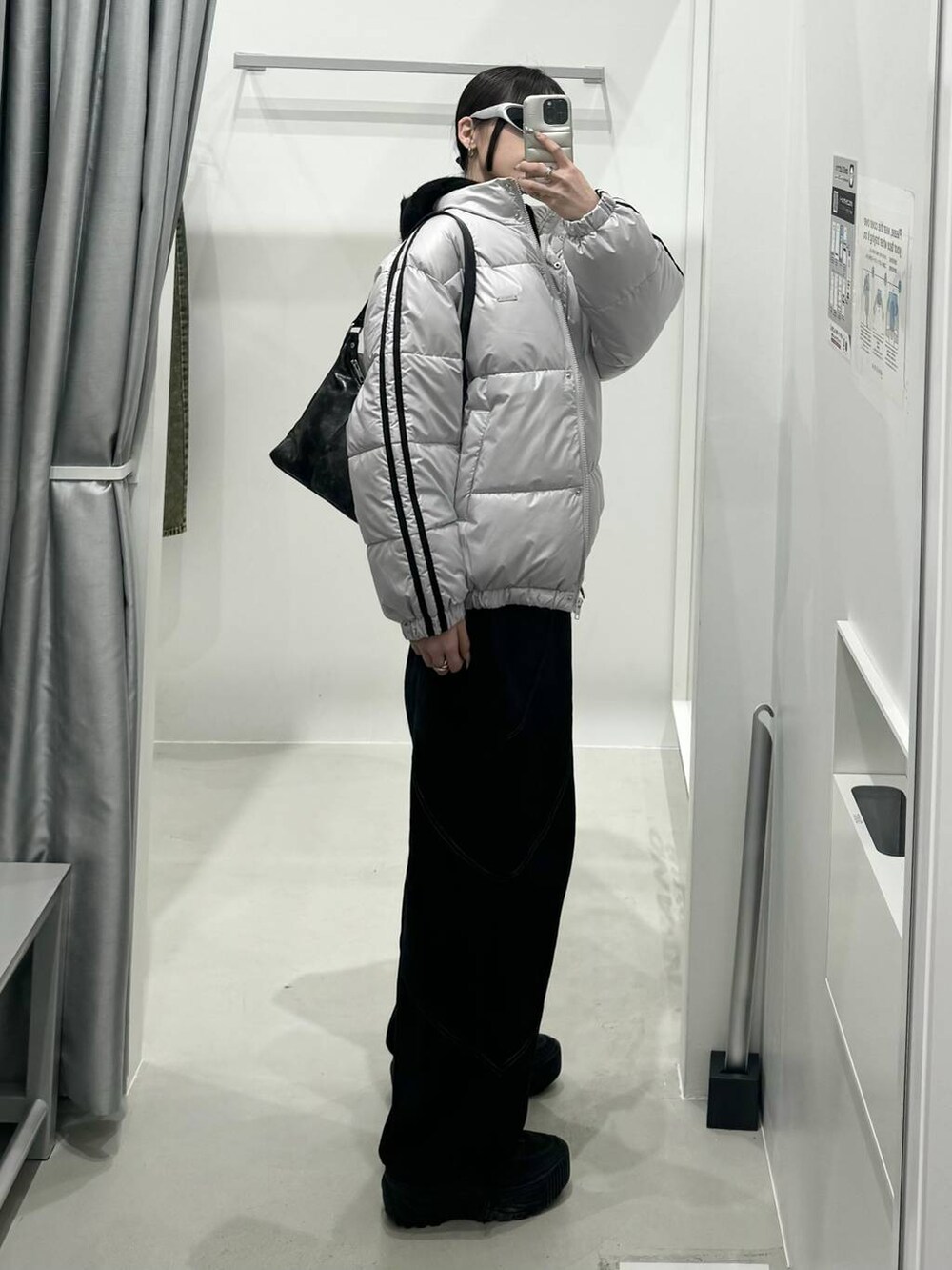 グレー系のダウンジャケット/コート、ブラック系のハンドバッグを着用したレディースの冬コーディネートの2枚目の写真