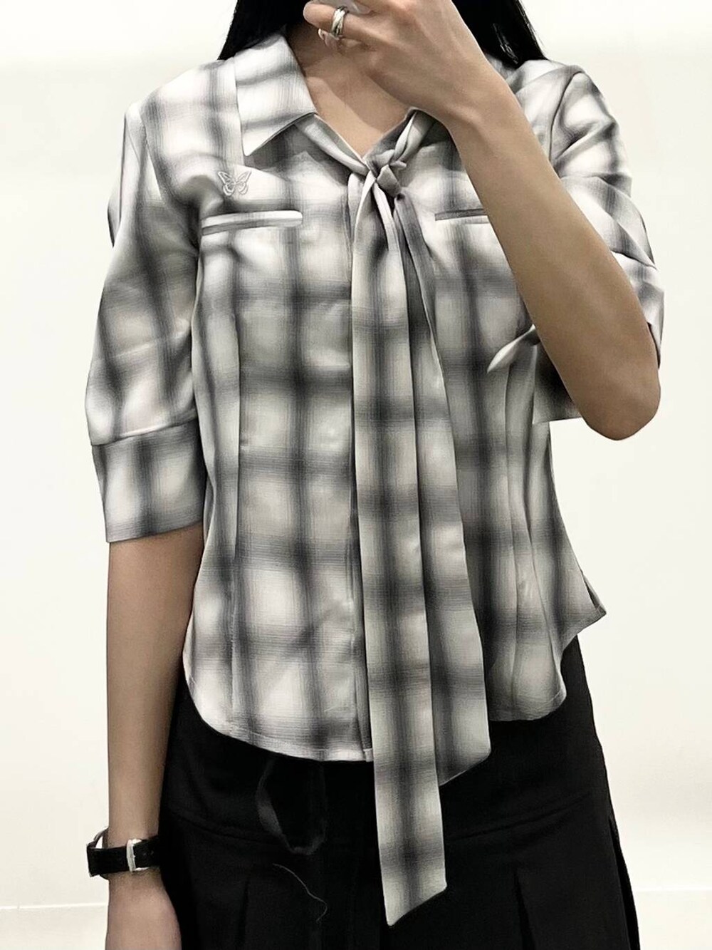 グレー系のシャツ/ブラウス、ブラック系のブーツ、グレー系のスカートを着用したレディースの春コーディネートの3枚目の写真