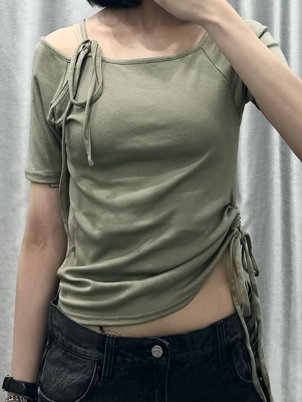 ブラック系のデニムパンツ、ブラック系のショルダーバッグ、グリーン系のTシャツ/カットソーを着用したレディースの夏コーディネートの3枚目の写真