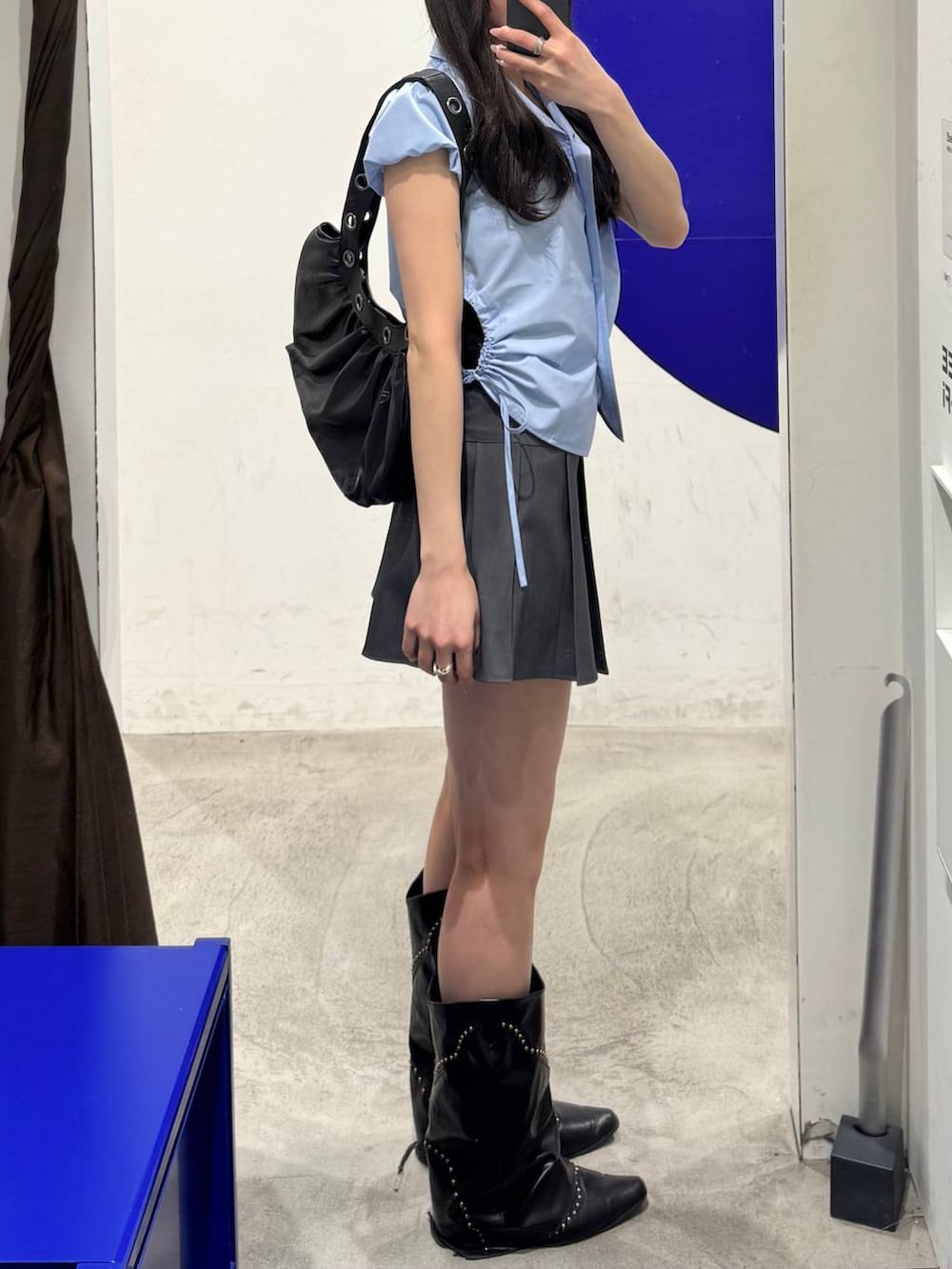 ブラック系のショルダーバッグ、ブルー系のシャツ/ブラウス、グレー系のスカートを着用したレディースの春コーディネートの2枚目の写真