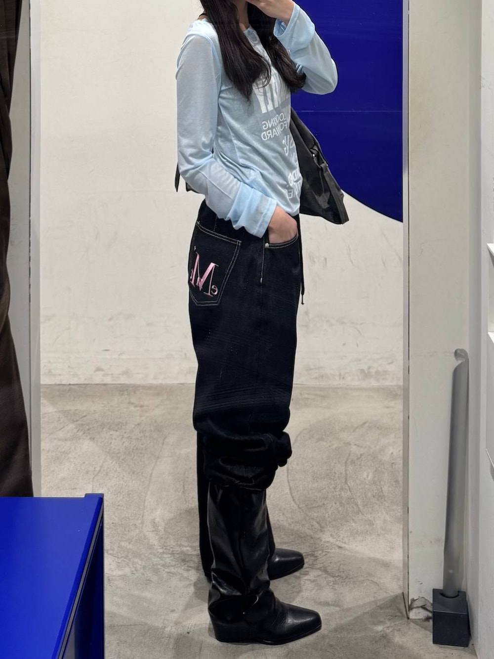 ブルー系のTシャツ/カットソー、ブラック系のデニムパンツ、ブラック系のブーツを着用したレディースの春コーディネートの2枚目の写真