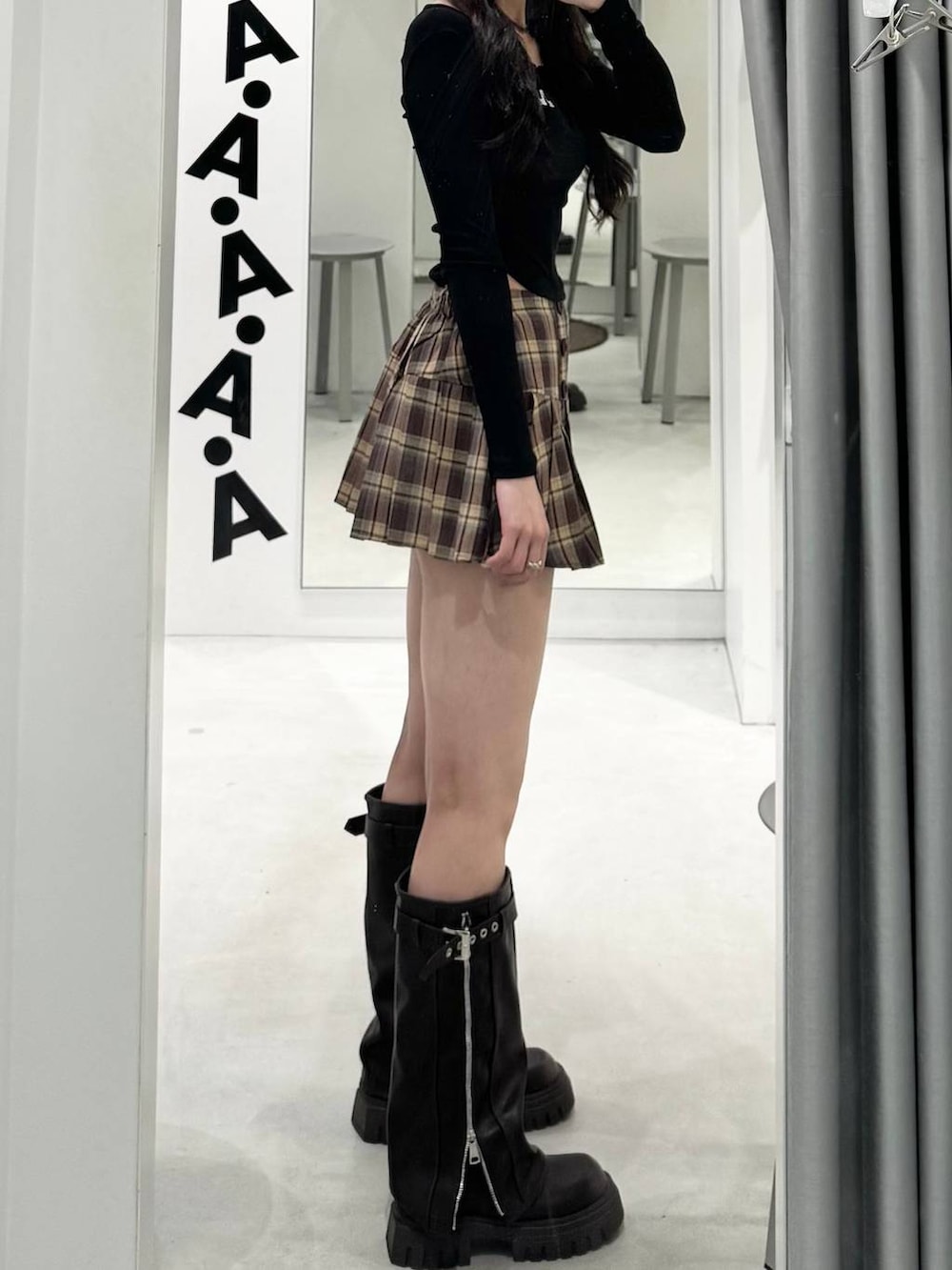 ベージュ系のスカート、ブラック系のTシャツ/カットソー、ブラック系のブーツを着用したレディースの秋コーディネートの2枚目の写真