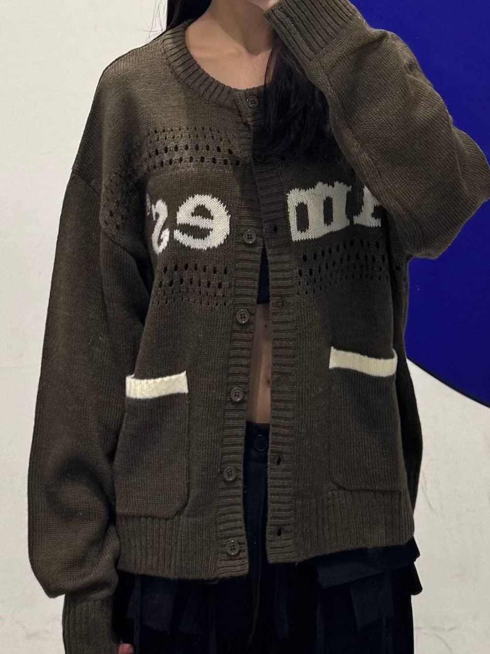 ブラウン系のカーディガン/ボレロ、ブラック系のスラックスを着用したレディースの冬コーディネートの3枚目の写真