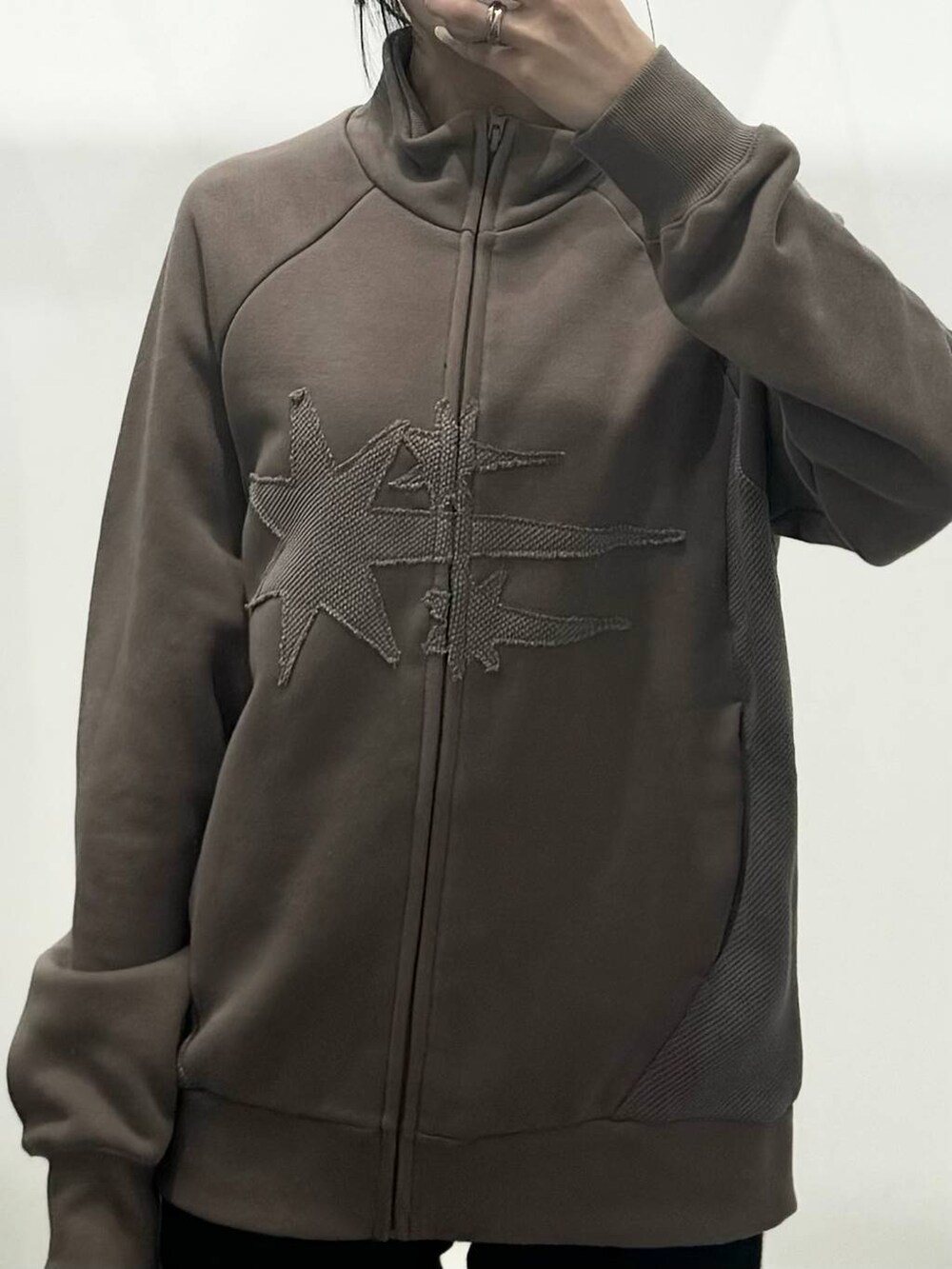 ベージュ系のパーカー、ブラック系のその他パンツを着用したレディースの秋コーディネートの3枚目の写真