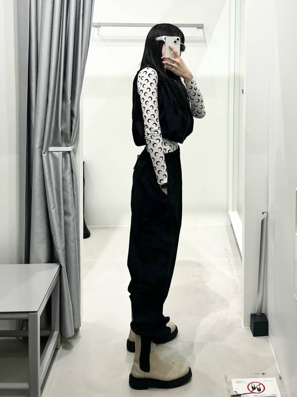 ブラック系のベスト、ブラック系のカーゴパンツを着用したレディースの春コーディネートの2枚目の写真